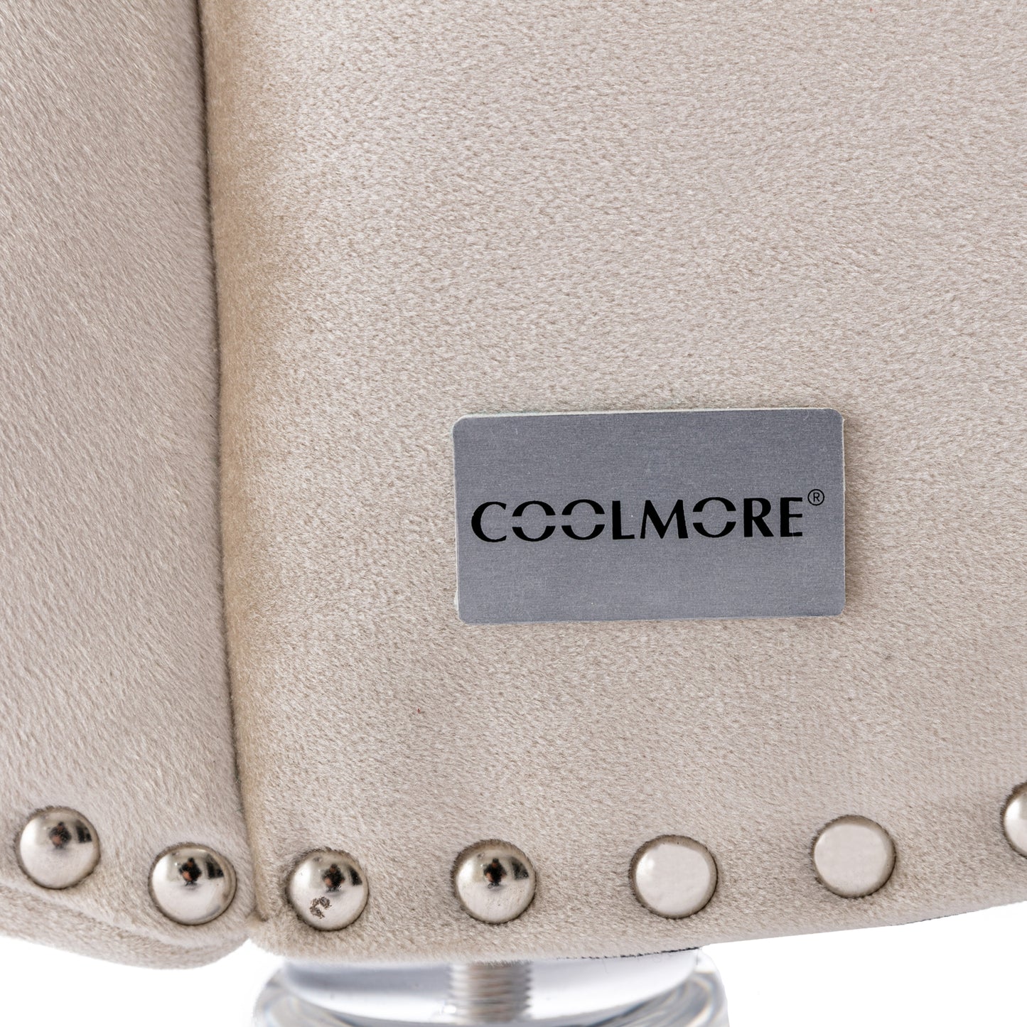 Closeup of beige velvet accent chair with silver nailhead trim detail