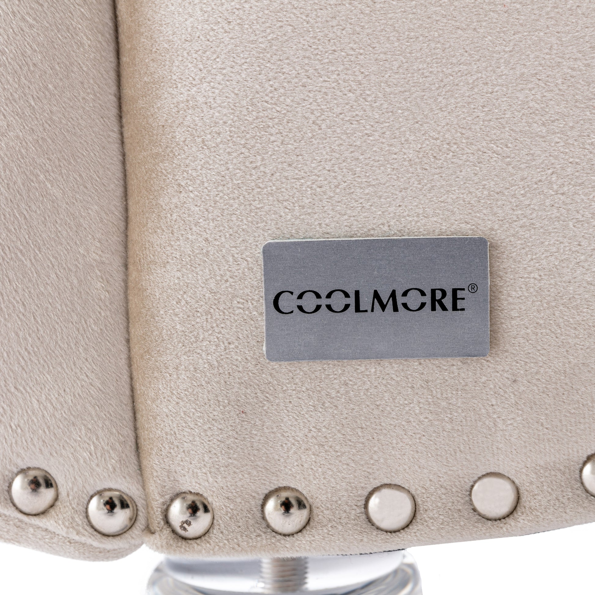 Closeup of beige velvet accent chair with silver nailhead trim detail