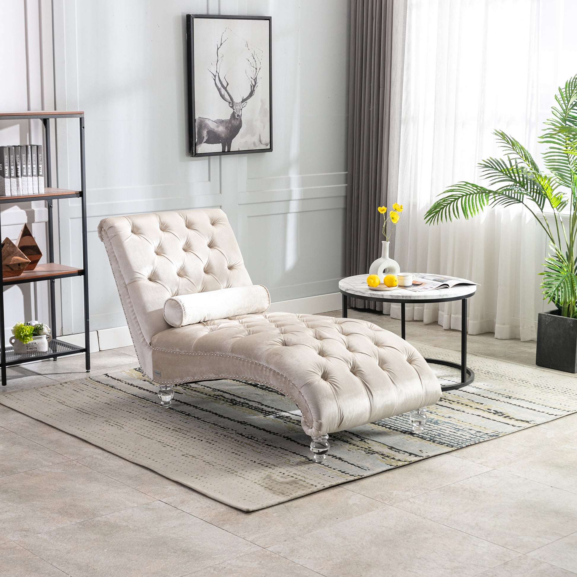 Tufted beige velvet chaise lounge with decorative nailhead trim and clear acrylic legs
