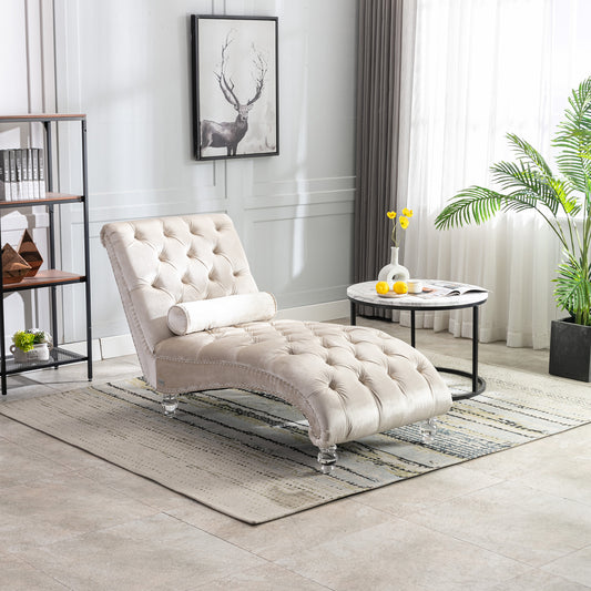 Tufted beige velvet chaise lounge with decorative nailhead trim and clear acrylic legs
