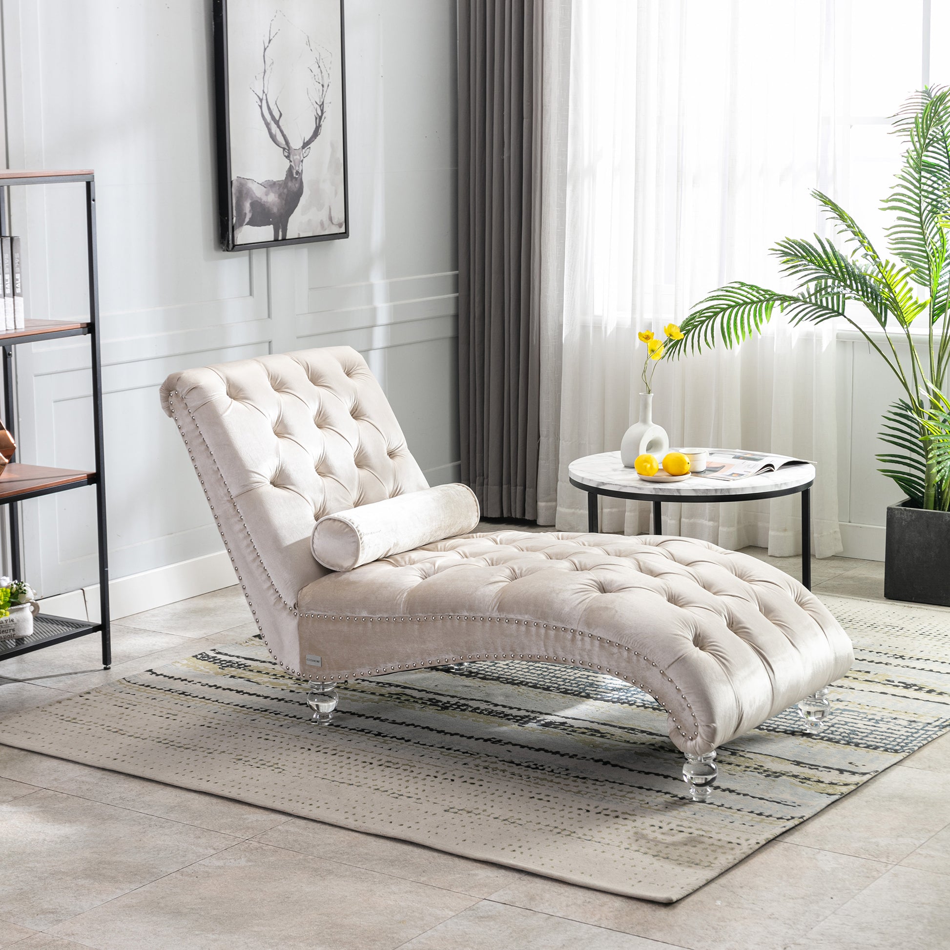 Elegant beige velvet chaise lounge with button tufting and silver nailhead trim perfect for a living room accent piece