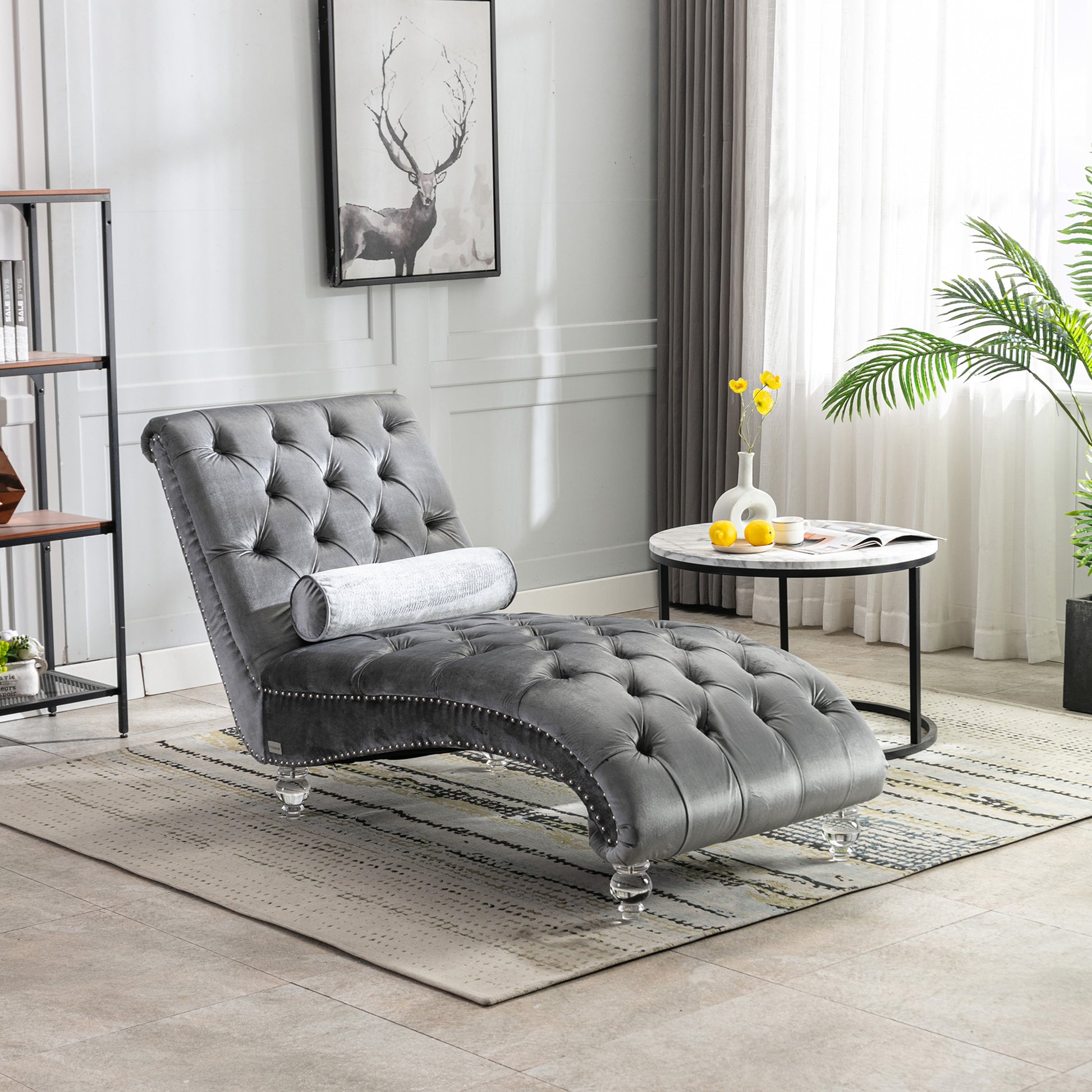 Grey velvet tufted chaise lounge with nailhead trim and crystal legs