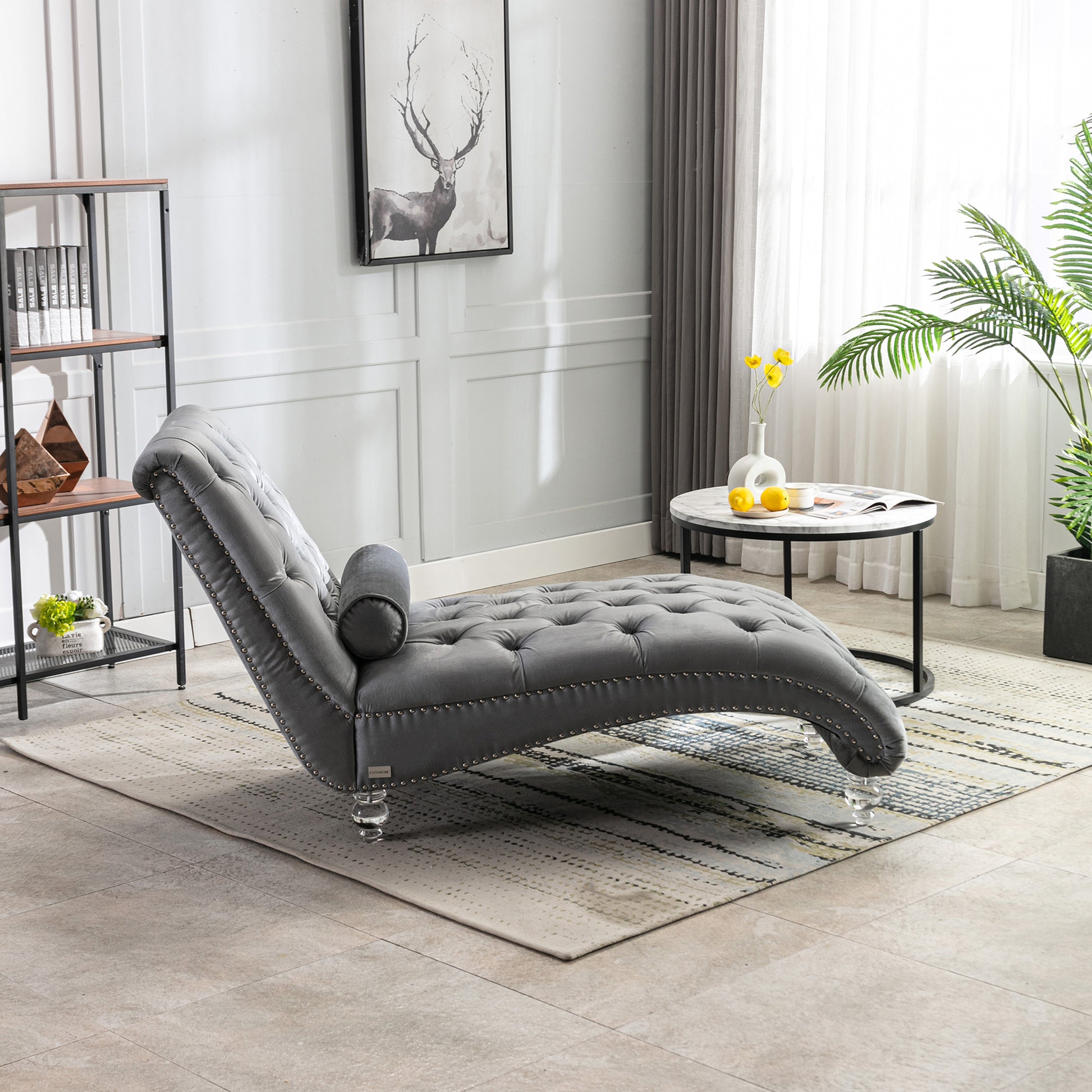 Tufted grey velvet chaise lounge with silver nailhead trim and clear acrylic legs