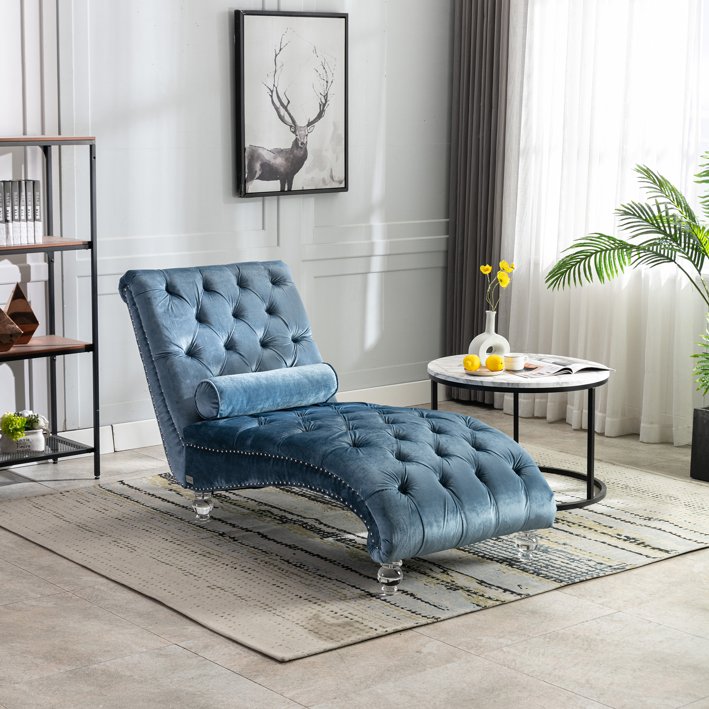 Tufted blue velvet chaise lounge with silver nailhead trim and crystal legs