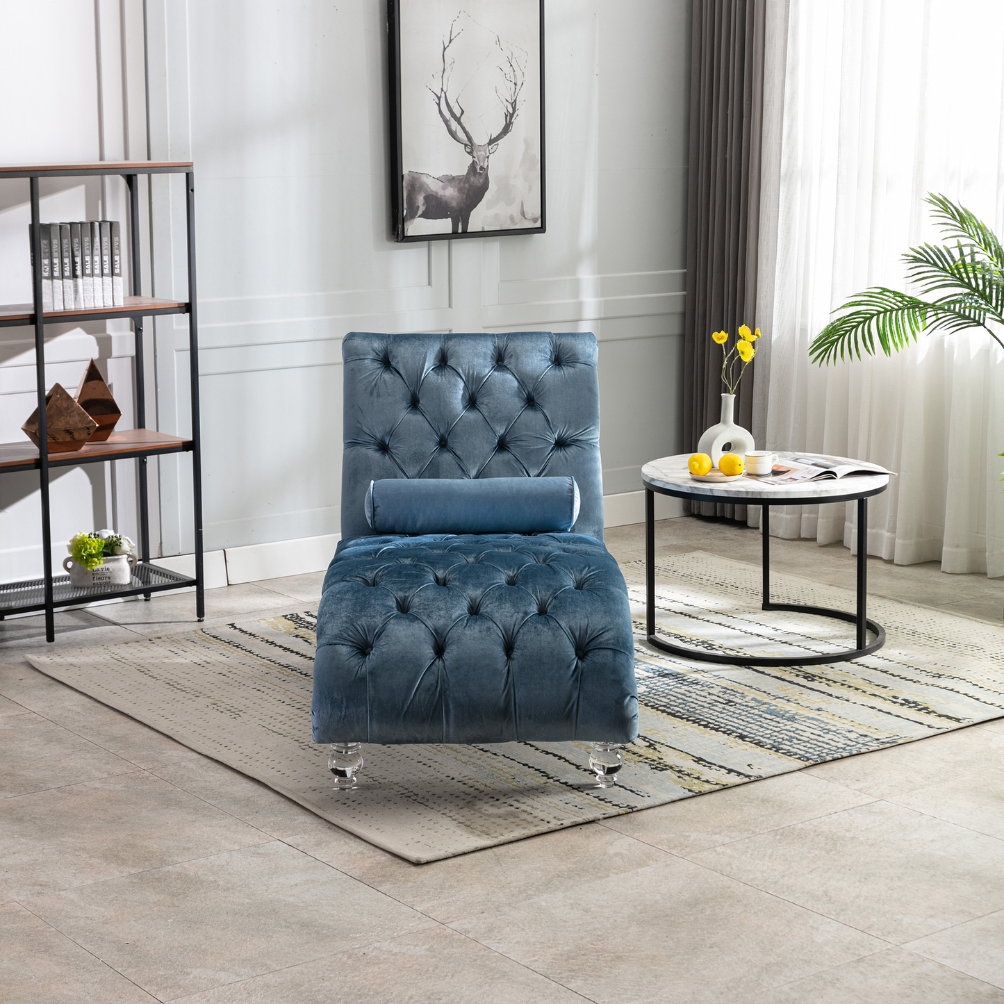 Blue velvet tufted chaise lounge with clear acrylic legs and a bolster pillow