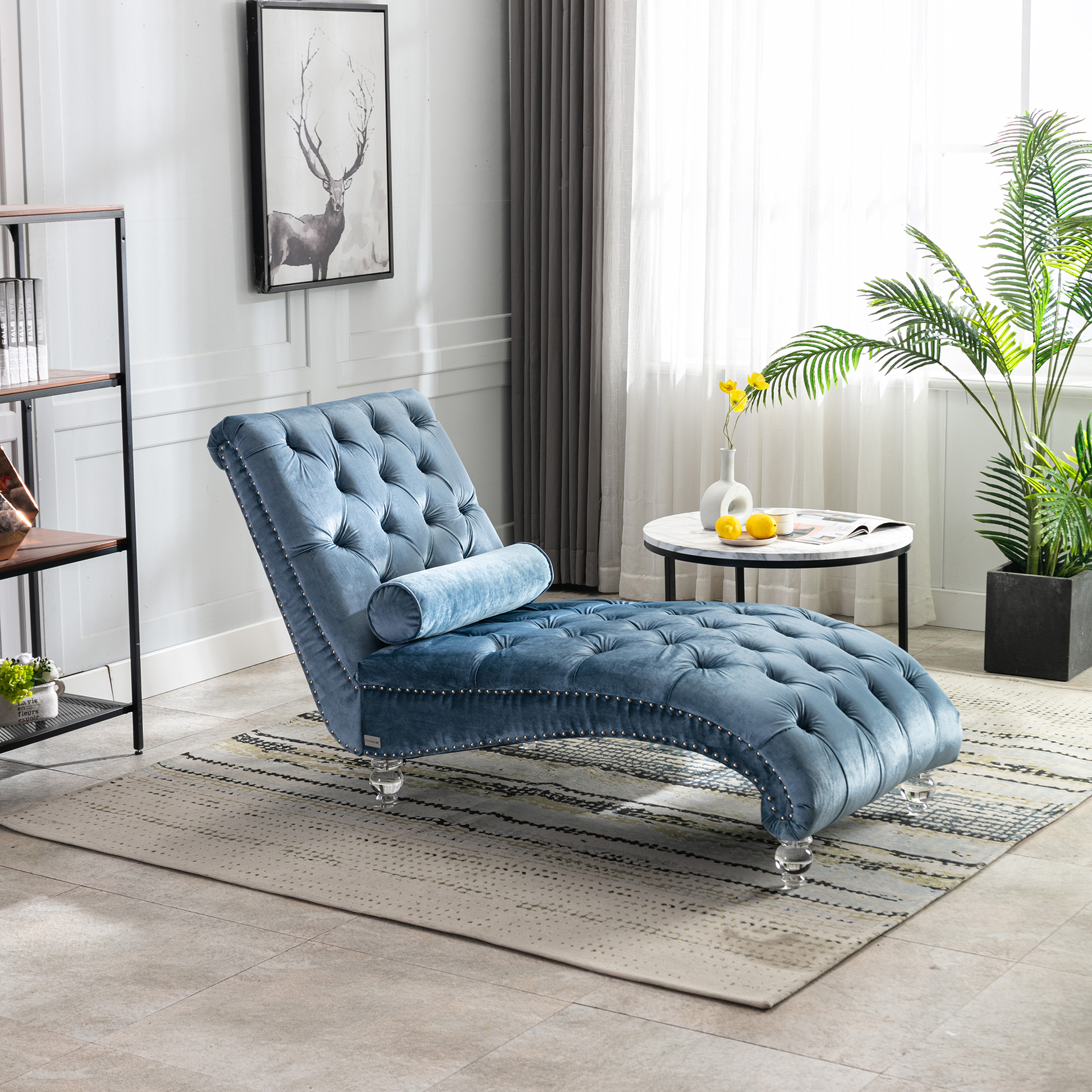 Blue velvet tufted chaise lounge with crystal legs and decorative studs perfect for a modern living room