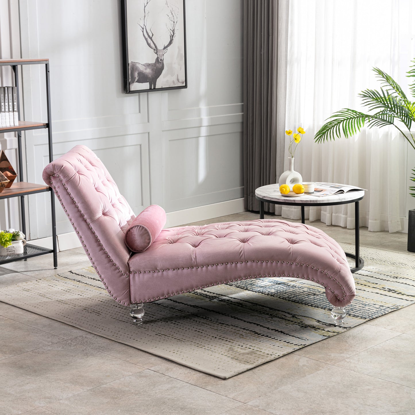 Pink velvet tufted chaise lounge with silver nailhead trim and bolster pillow