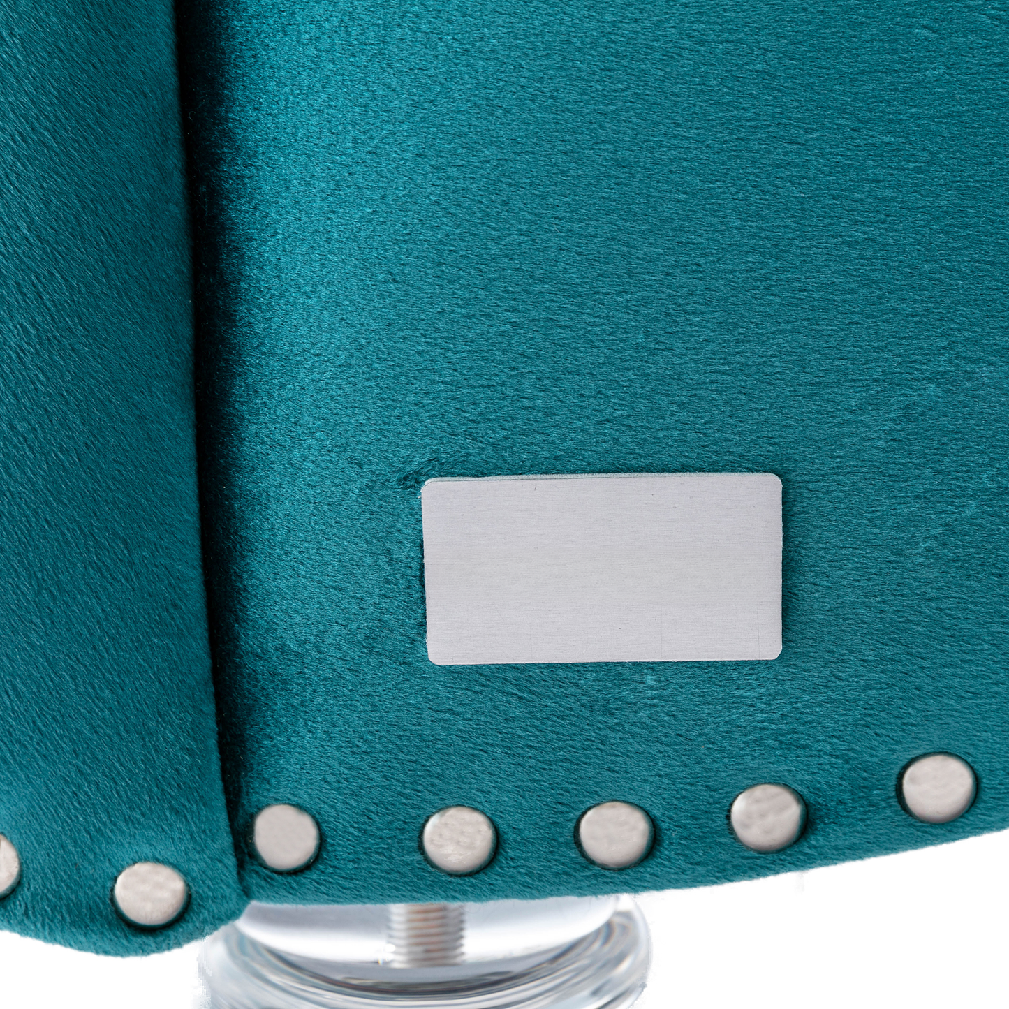 Teal velvet upholstery detail with silver stud accents for a luxurious armchair