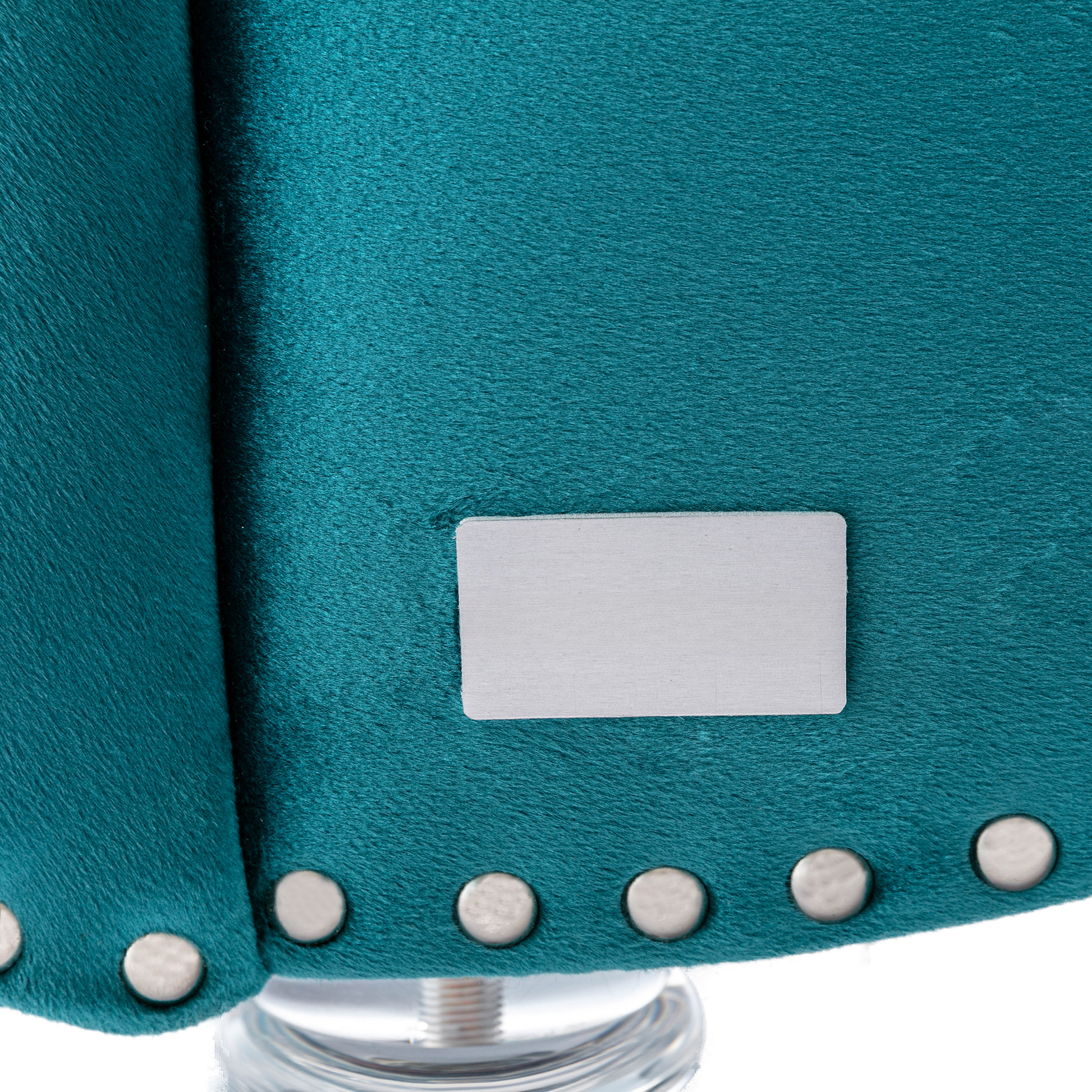 Teal velvet upholstery detail with silver stud accents for a luxurious armchair