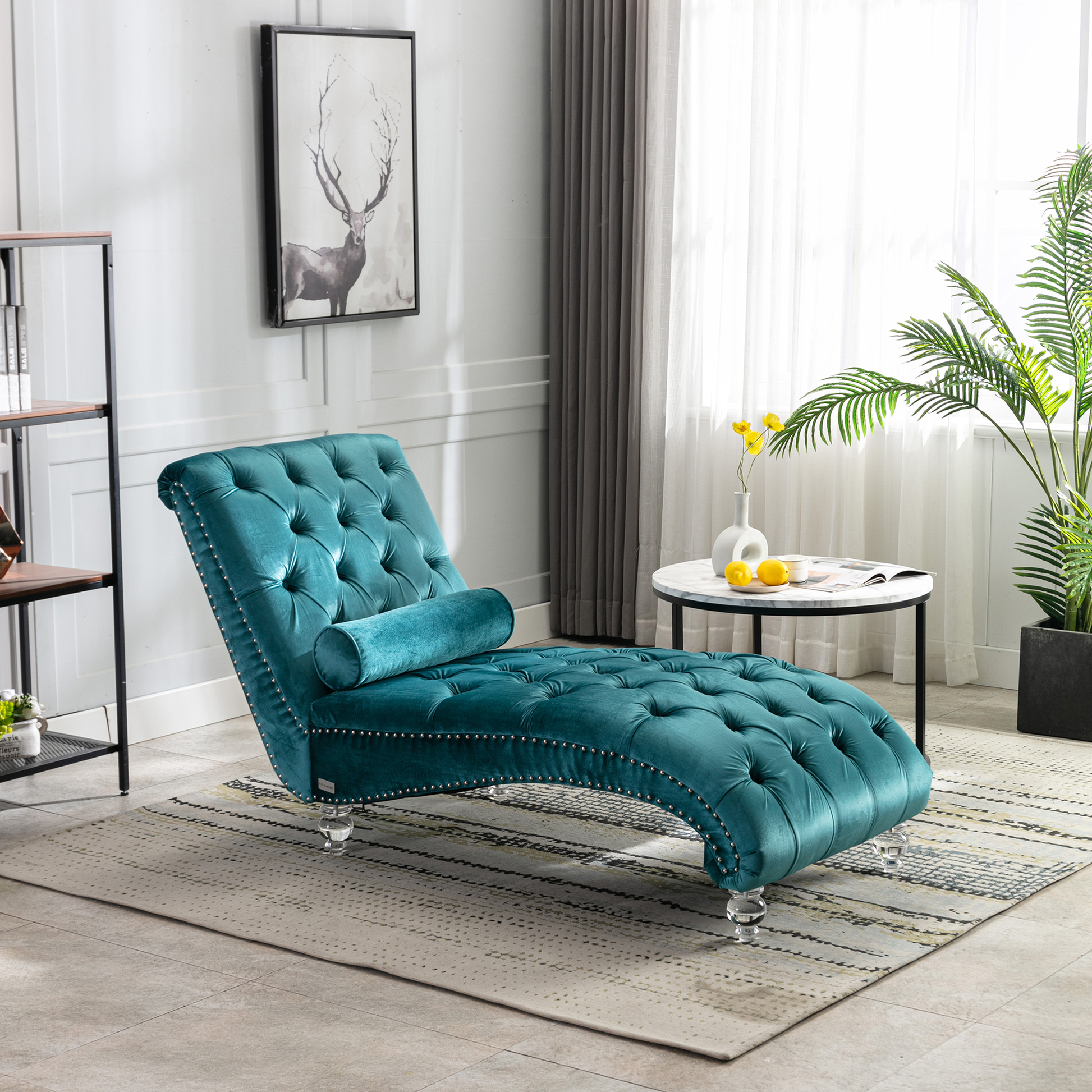 Teal velvet tufted chaise lounge with silver nailhead trim and plush bolster pillow