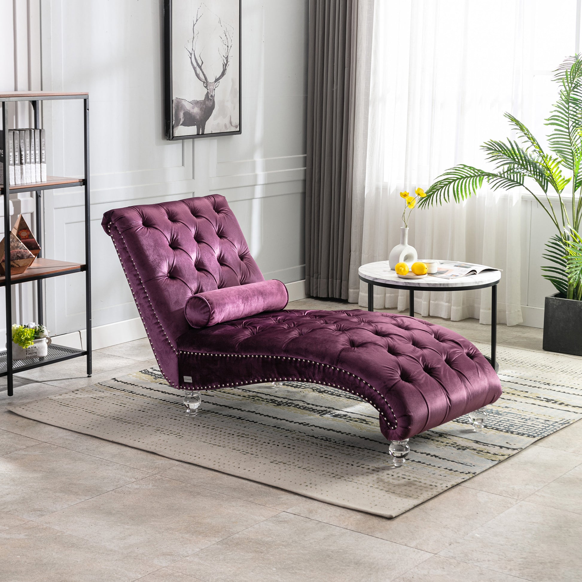 Tufted purple velvet chaise lounge with nailhead trim and a bolster pillow