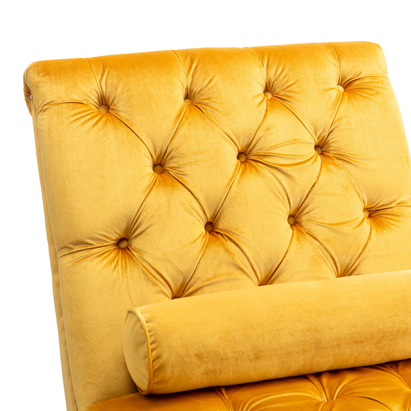 Closeup of a tufted gold velvet chaise lounge with a bolter pillow