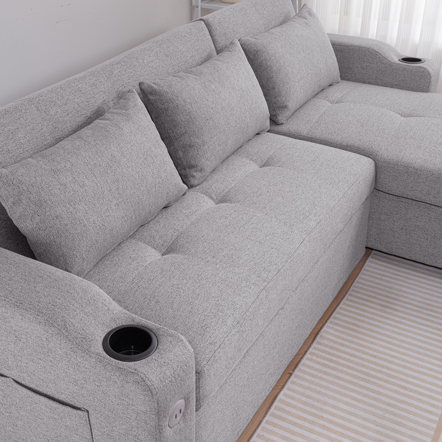 Comfortable grey fabric sectional sofa with plush cushions and builtin cup holders