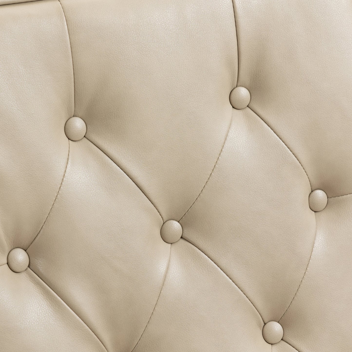 Closeup of beige faux leather tufted upholstery with button accents