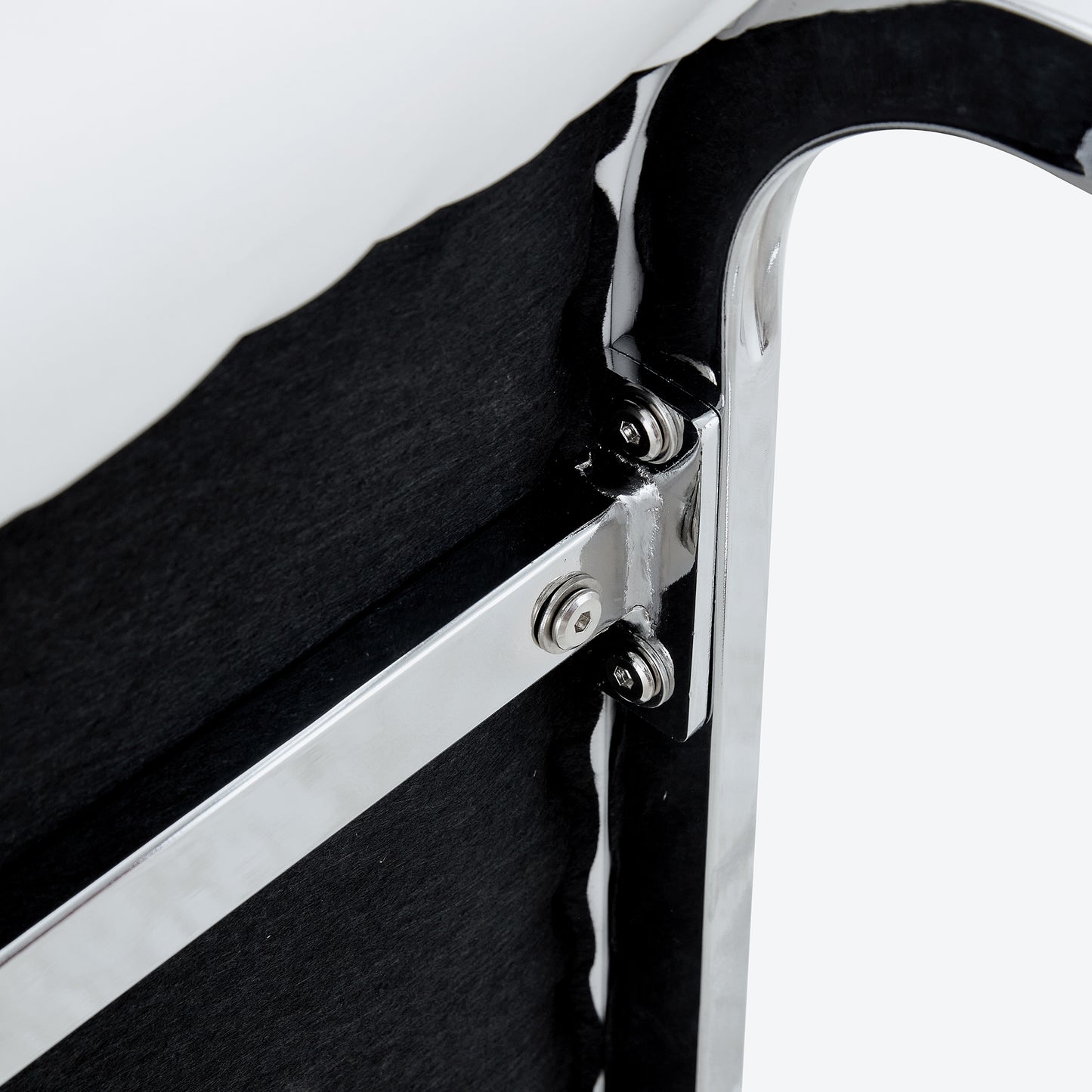 Closeup of chromeplated metal frame with black textured fabric backing showing secure bolt attachments for durability