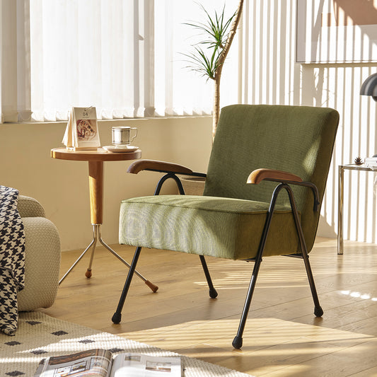 Green corduroy accent chair with dark metal legs and wooden armrests