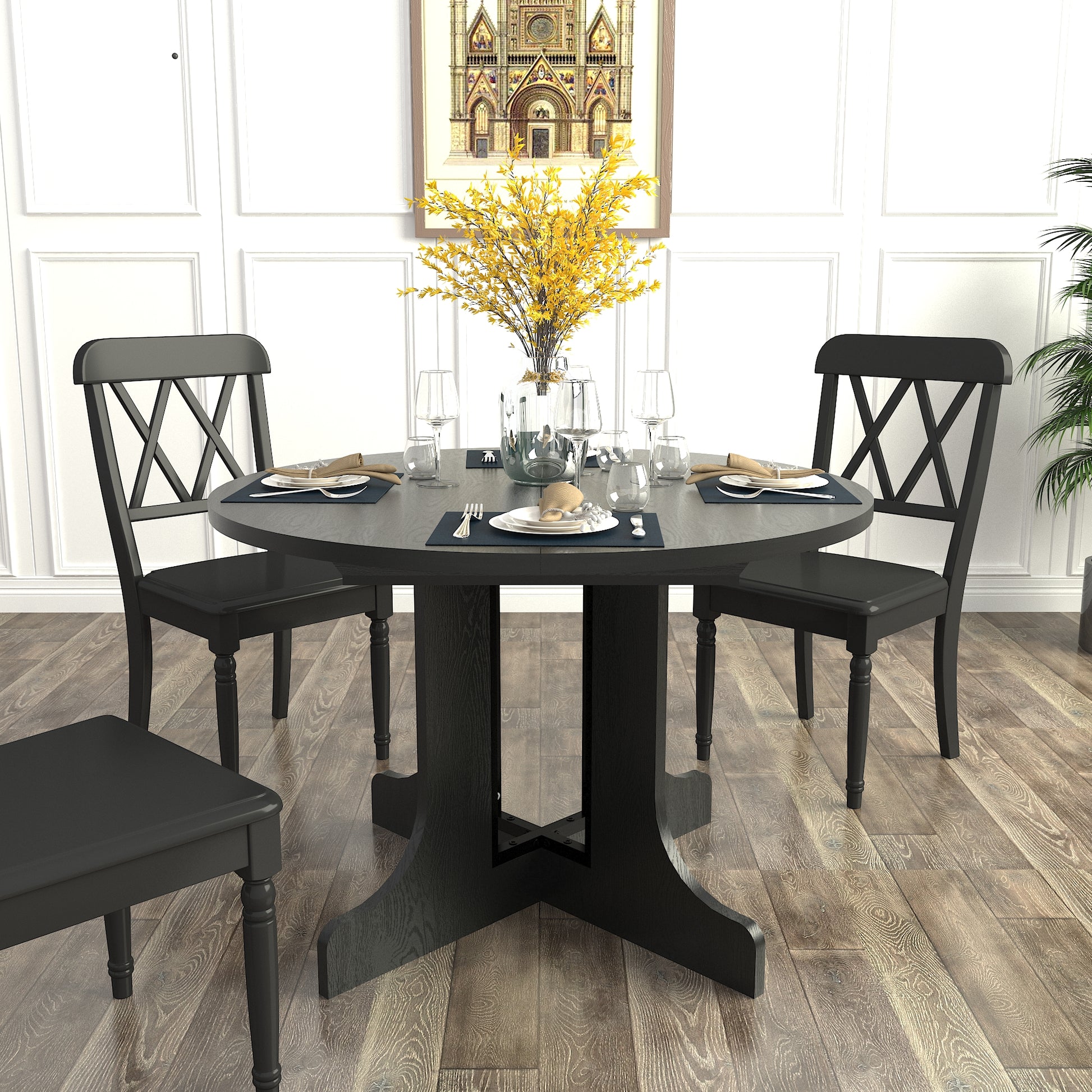 Black round pedestal dining table set with four chairs and Xback design