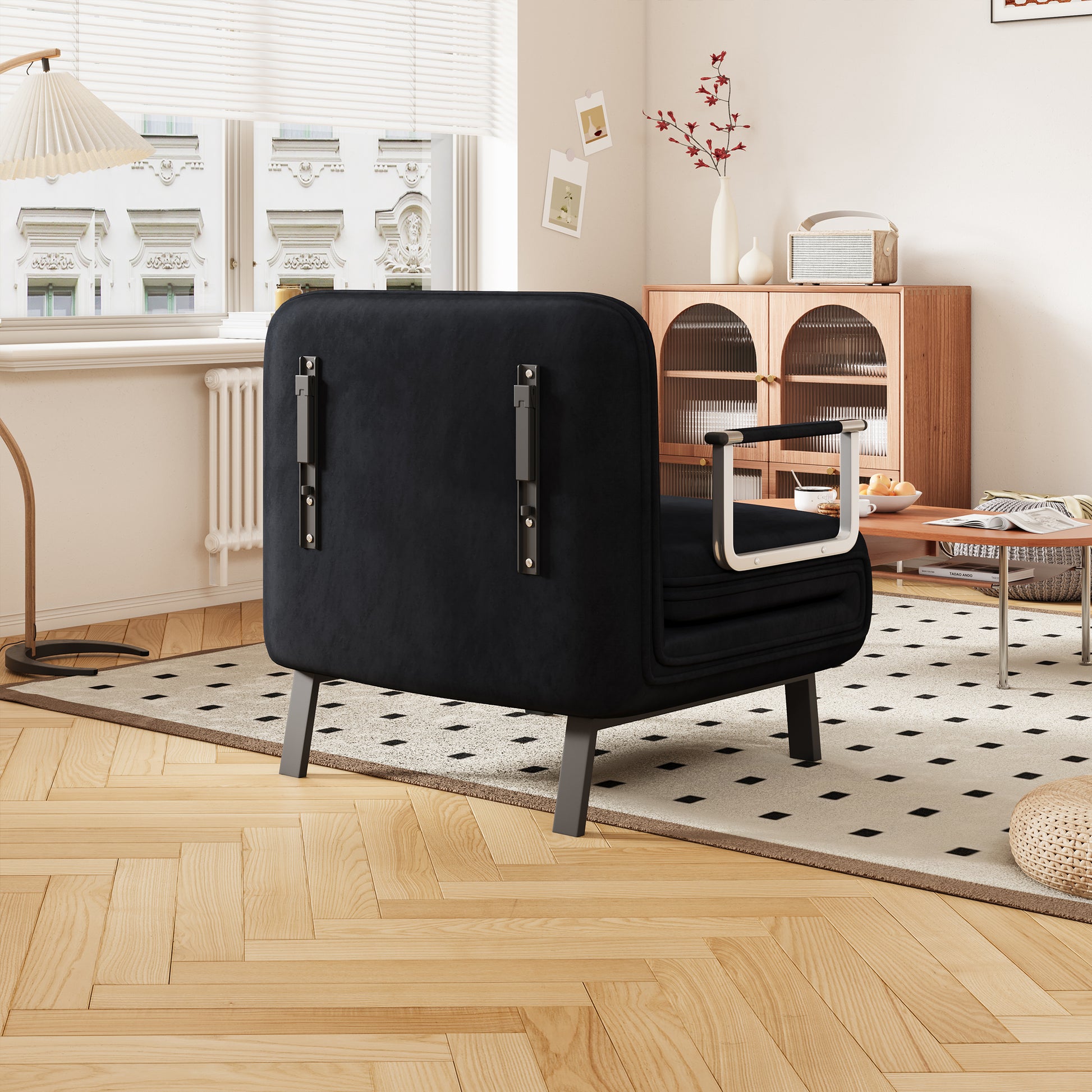 Black velvet armchair with modern metal legs and silver armrests suitable for living rooms