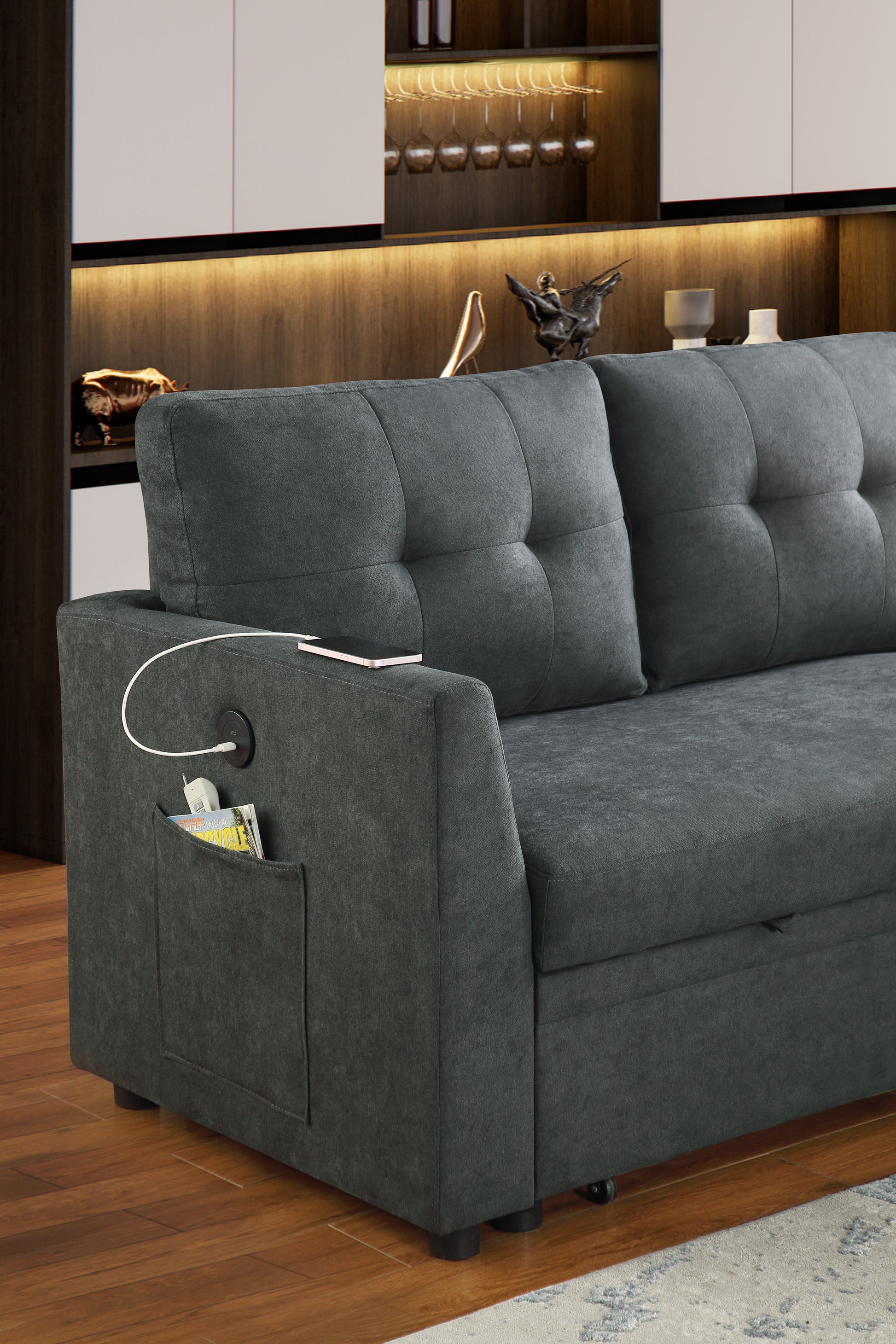 Dark grey tufted sofa with builtin armrest pocket and charging port perfect for modern living rooms