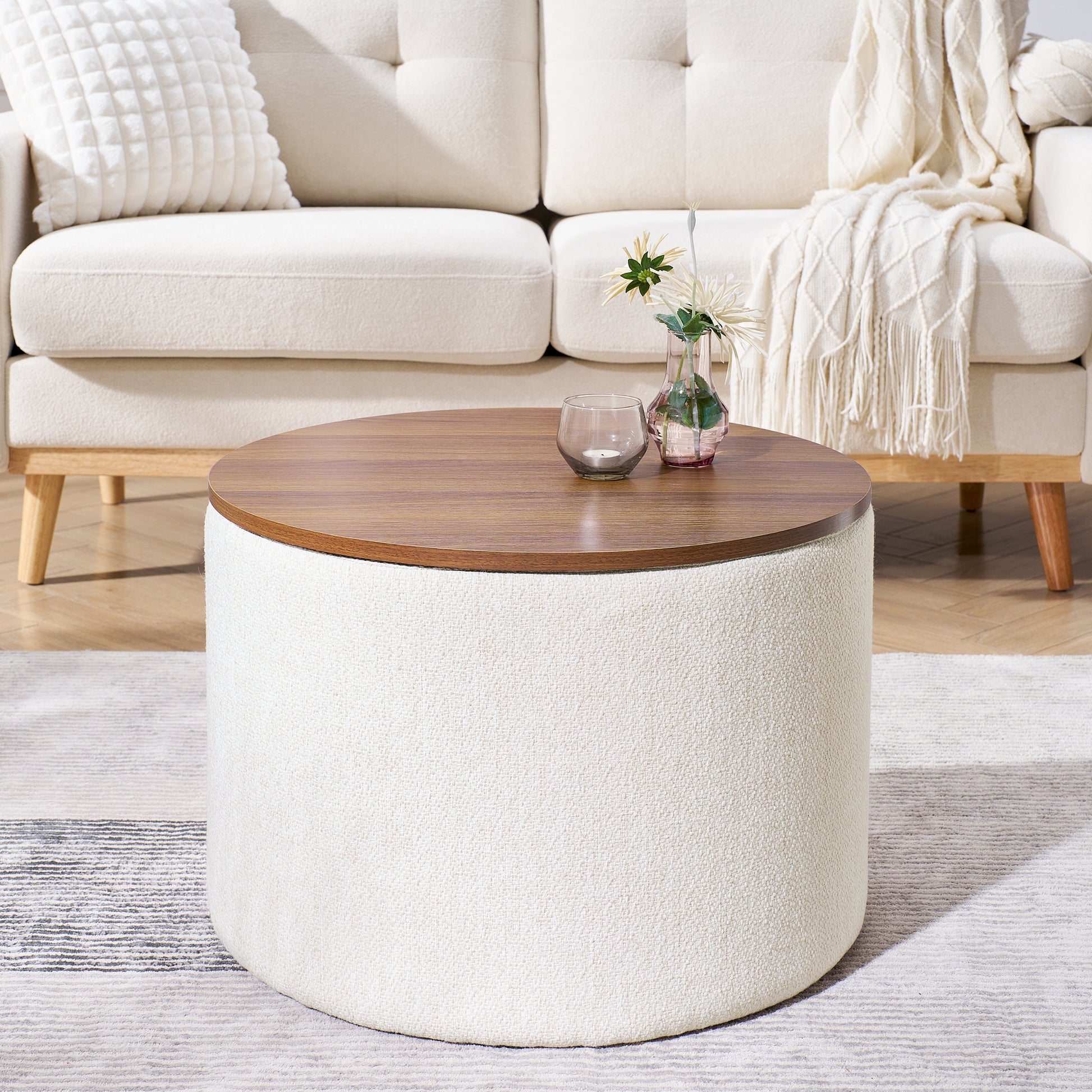 Round storage ottoman with a textured offwhite fabric base and walnutfinish lifttop