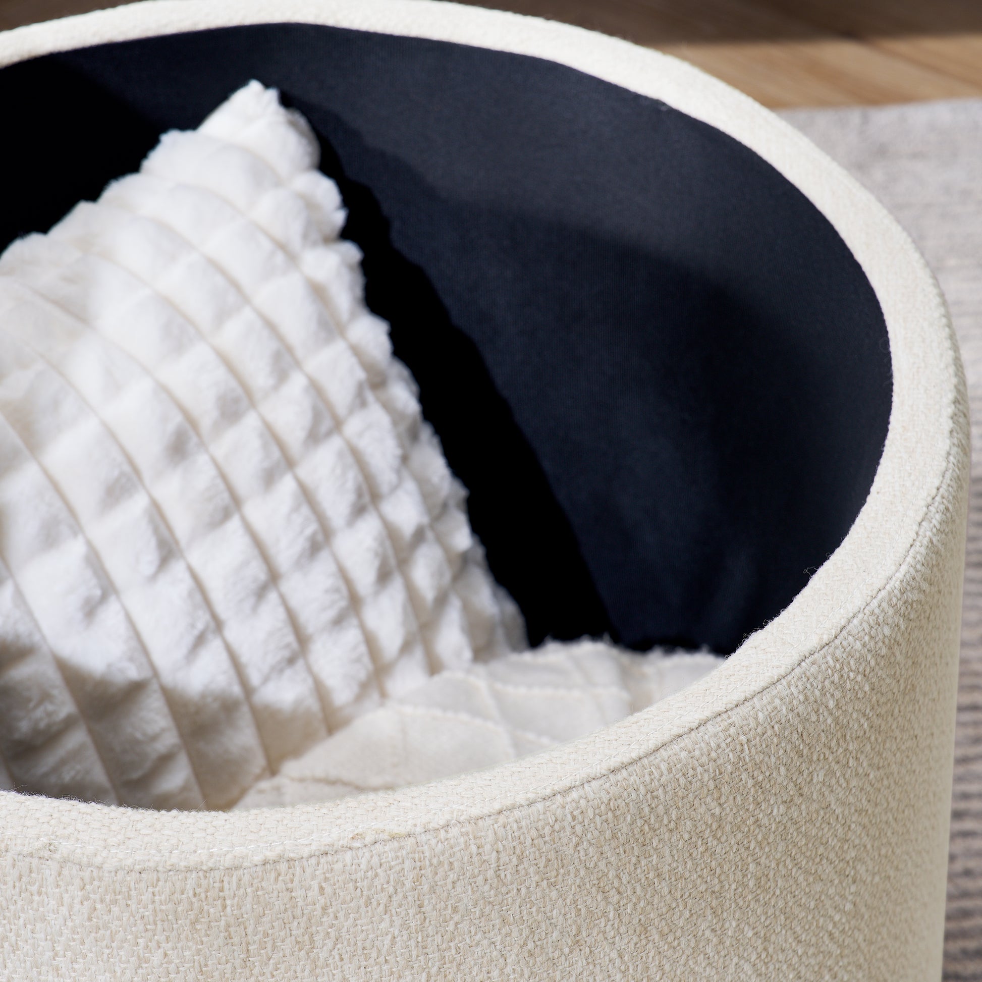 Cream boucle upholstered ottoman with a white tufted cushion inside