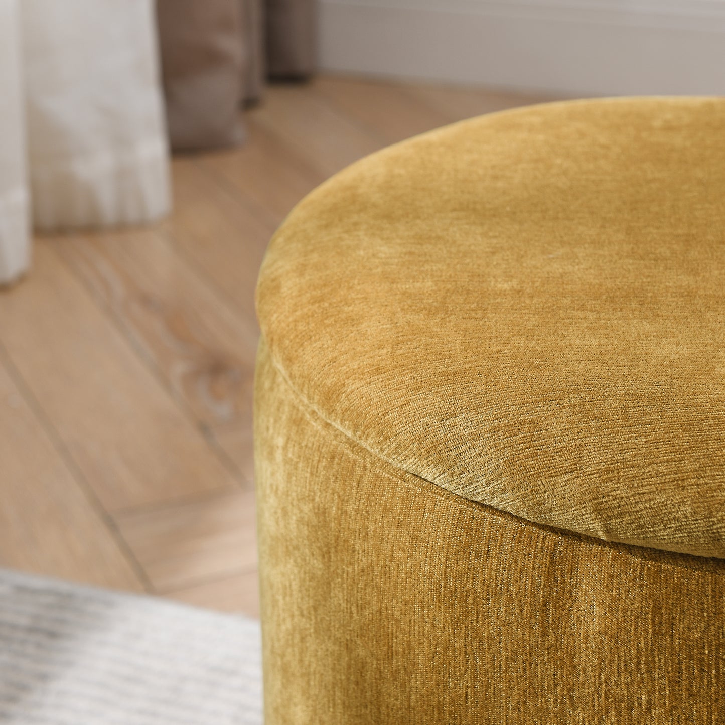 Textured mustard velvet ottoman with a circular top and short cylindrical base