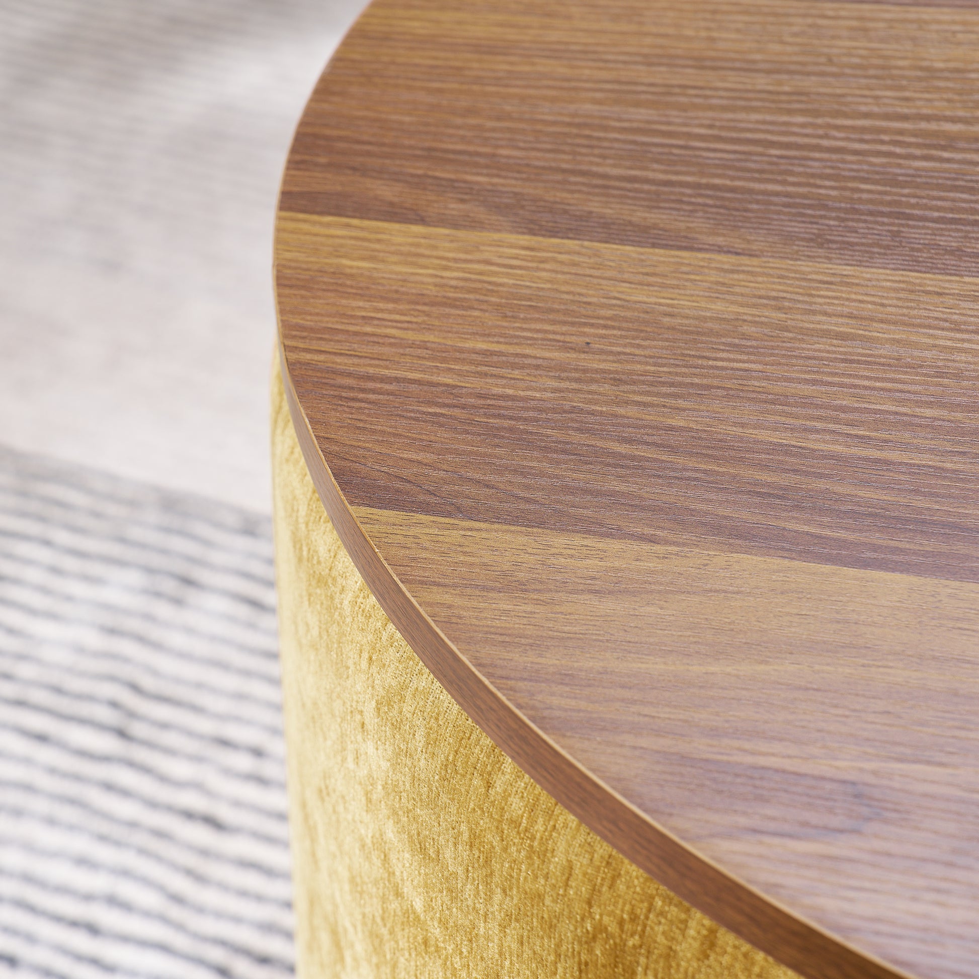 Round accent table with warm wood top and textured yellow fabric base