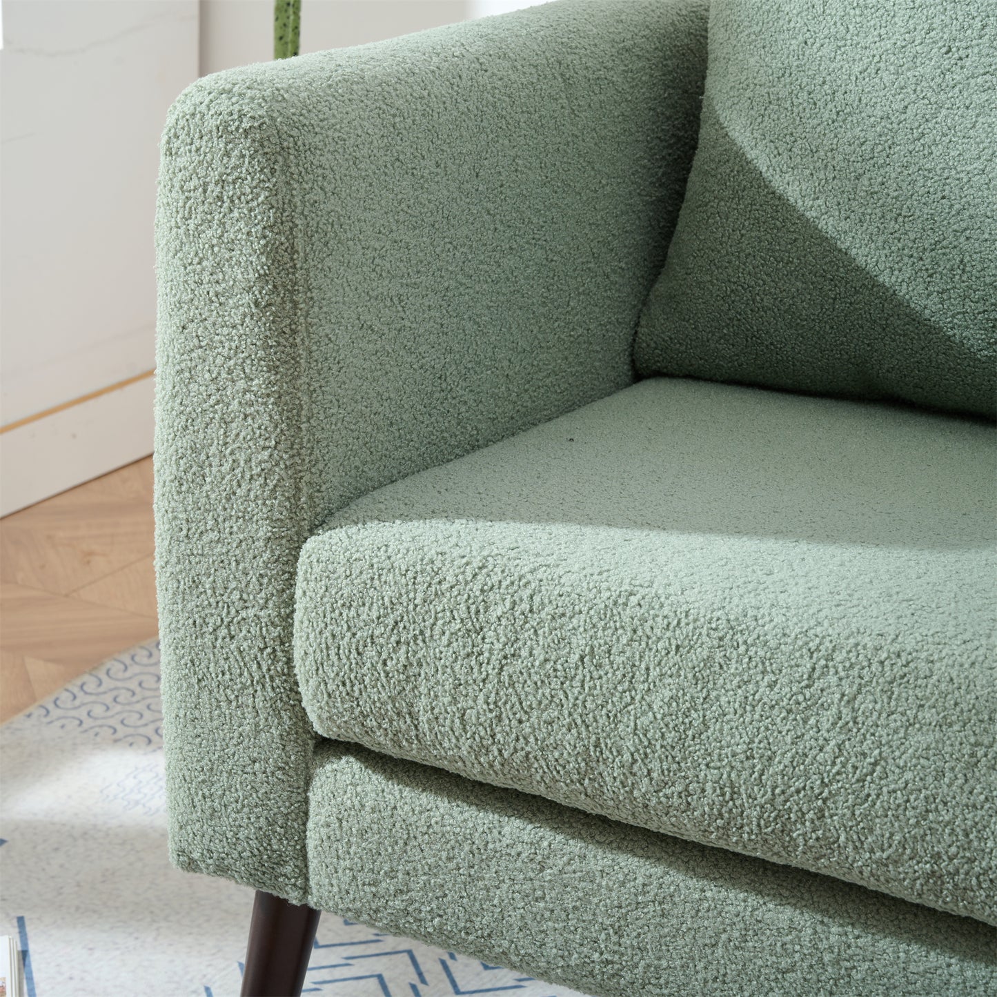 Cozy sage green boucl armchair featuring plush textured fabric and a modern silhouette for any living space