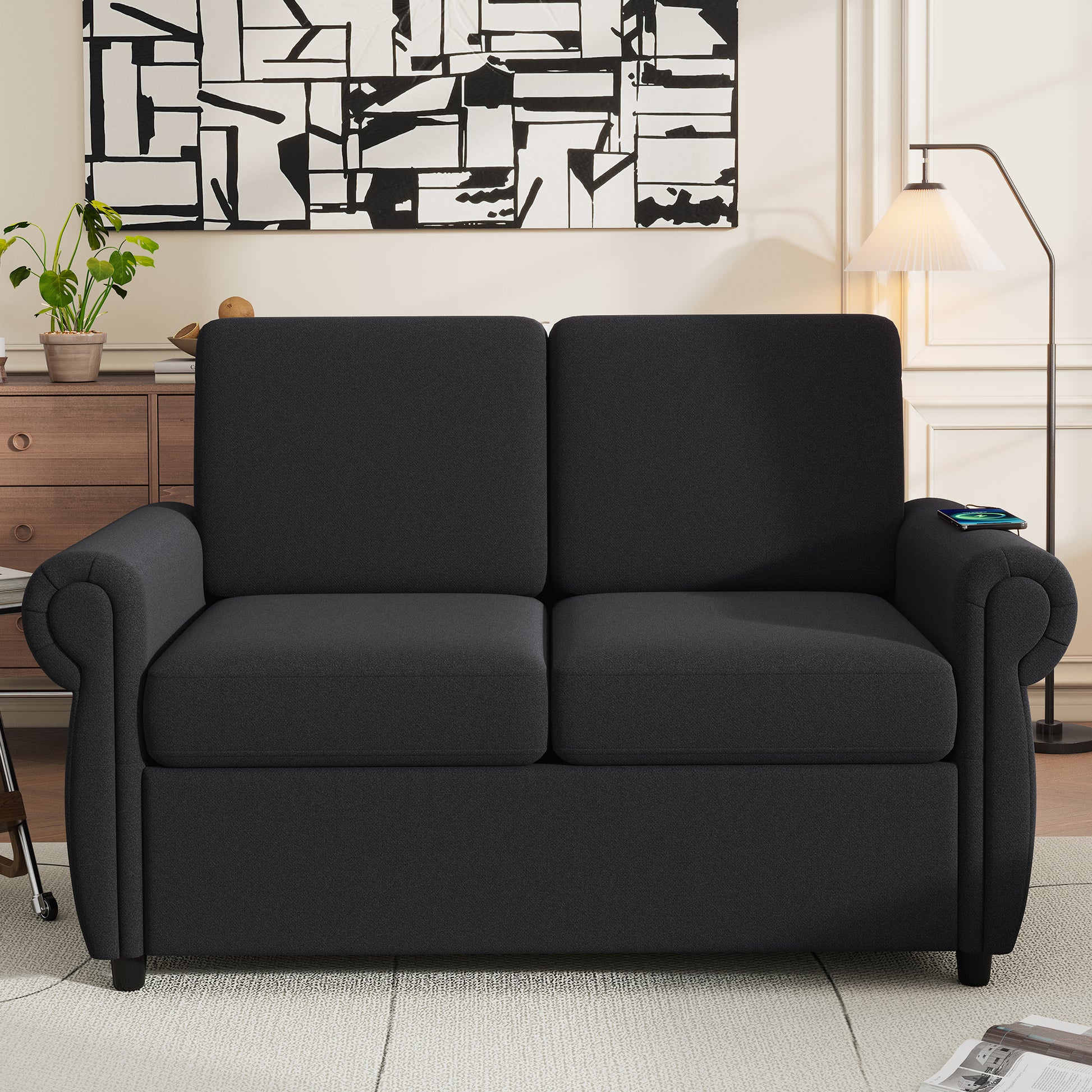 Dark gray upholstered sofa with rolled arms and plush cushions perfect for a living room