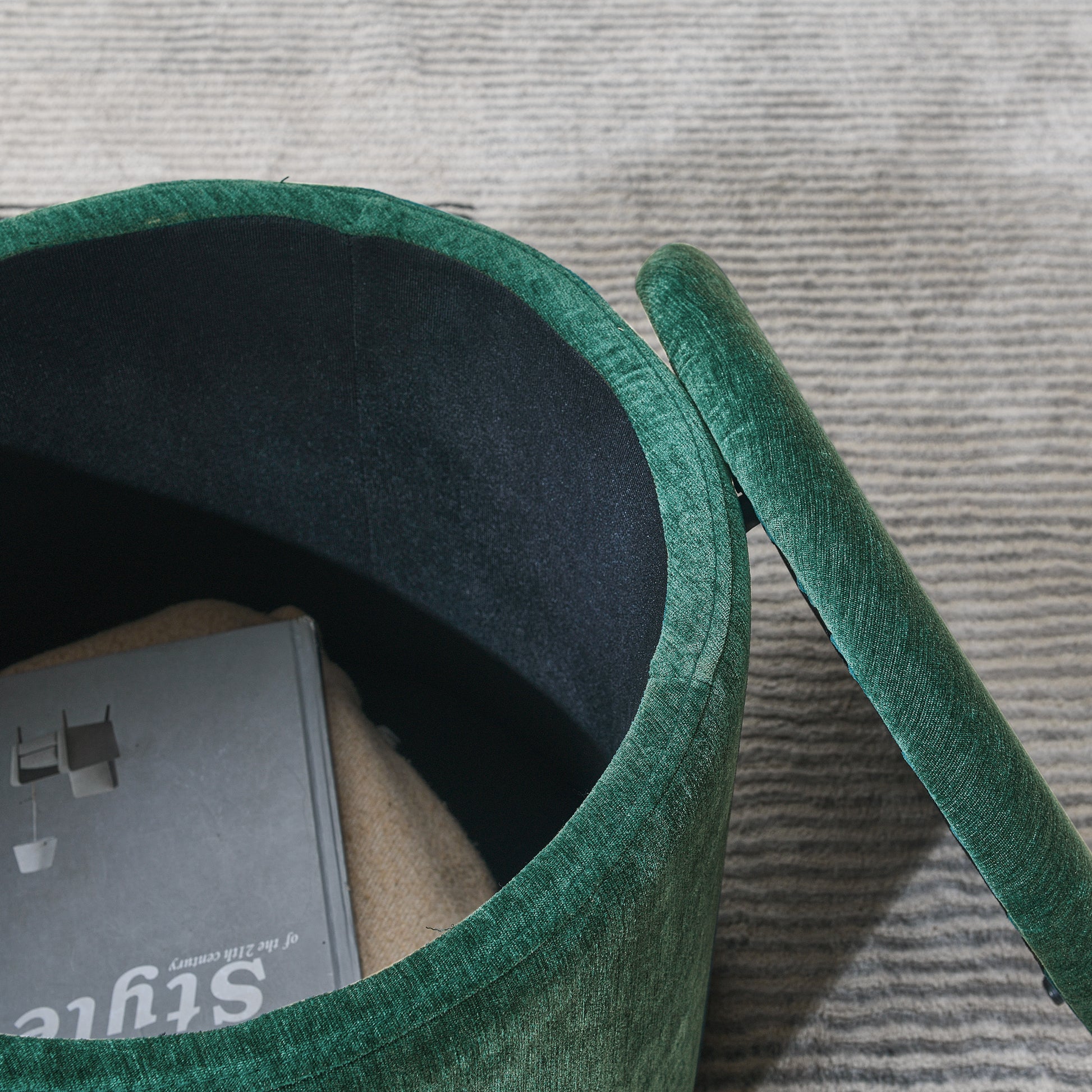 Deep green velvet storage ottoman with an open lid showing fabric lining and stored items