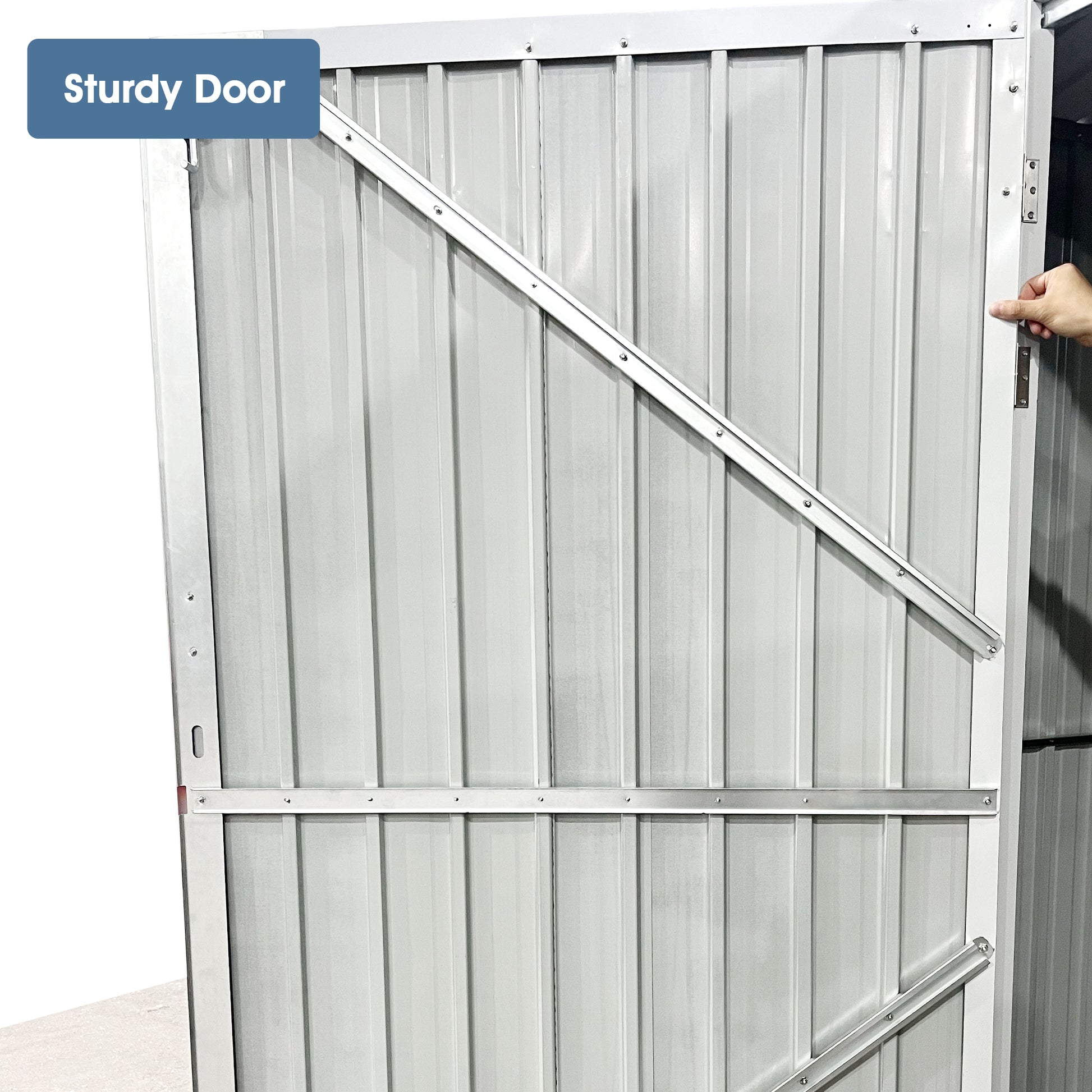 Silver corrugated metal shed door with diagonal bracing for stability