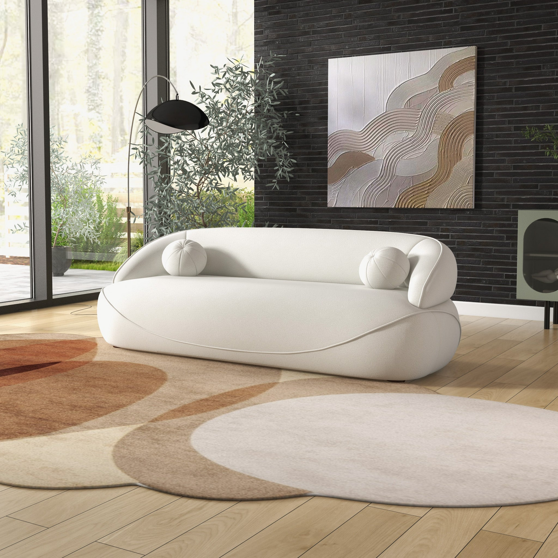 White boucle sofa with rounded arms and two round pillows modern living room seating