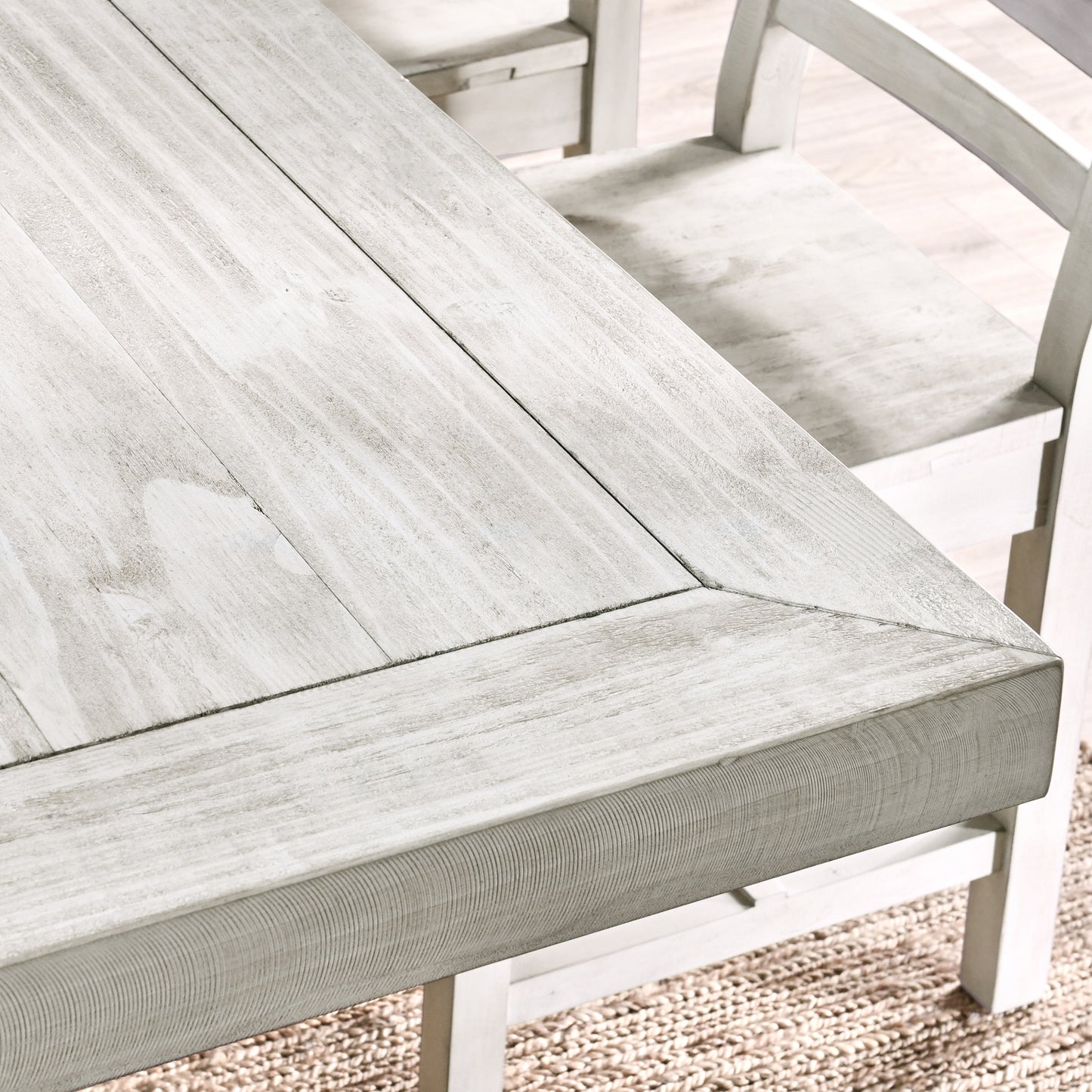 Distressed white wood dining table with planked surface and bevelled edge