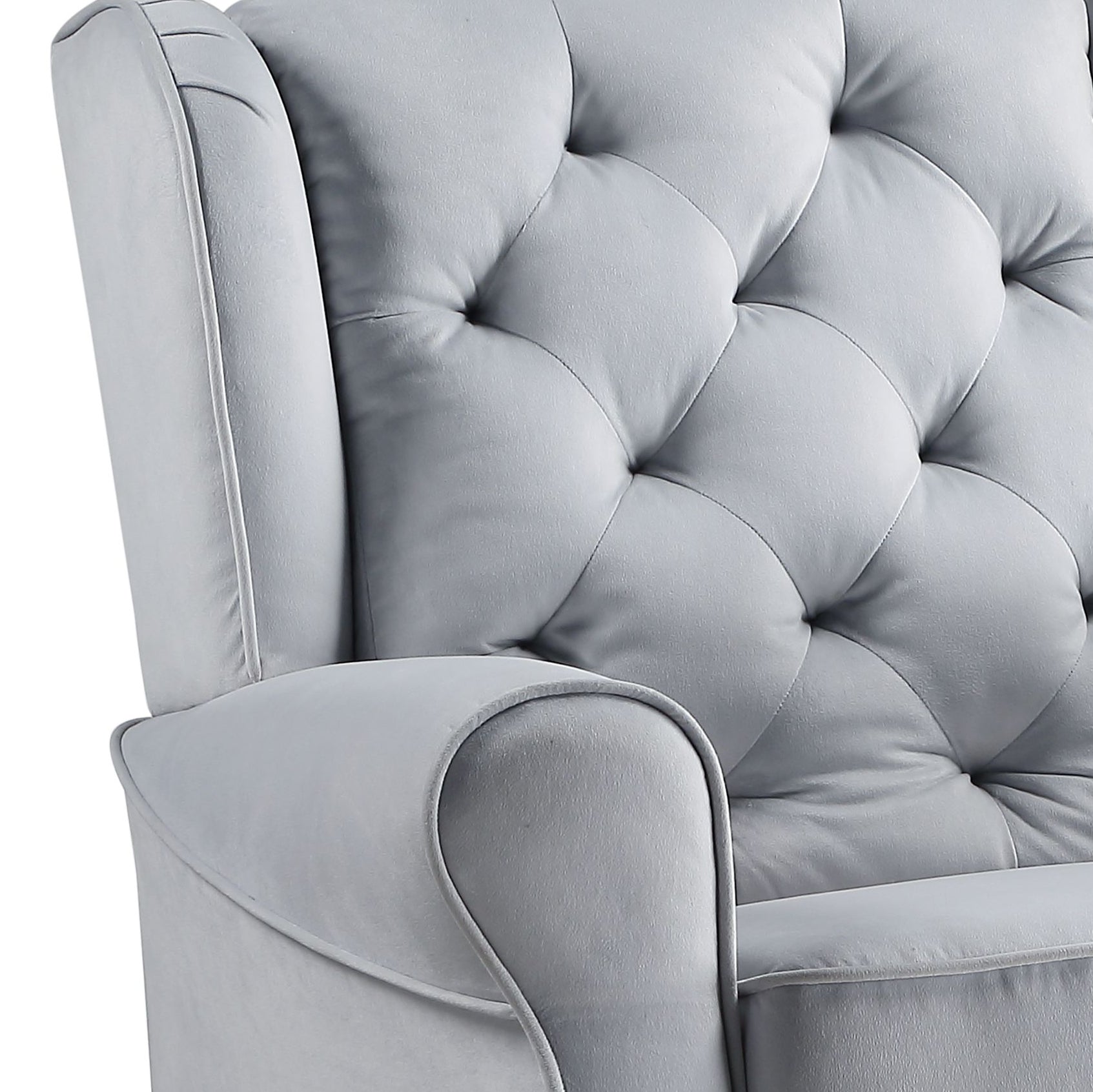 Closeup of a light gray tufted velvet armchairs armrest and back