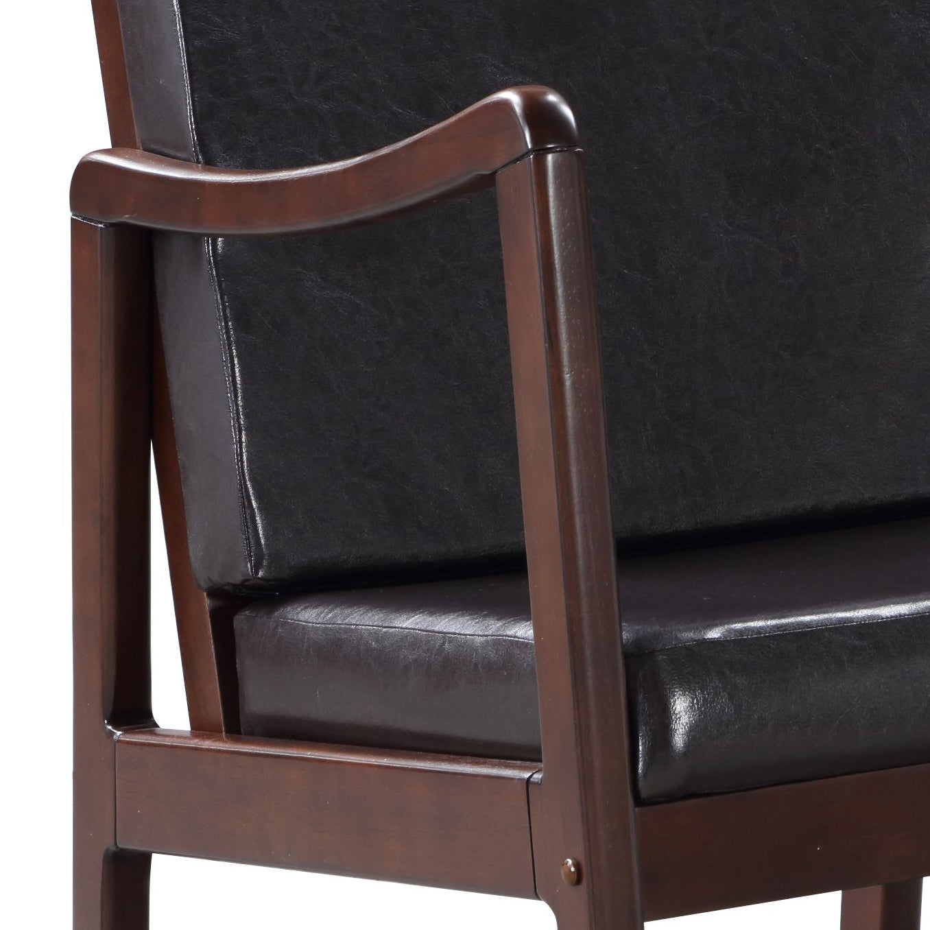 Closeup of a black faux leather armchair with dark wood frame and armrest