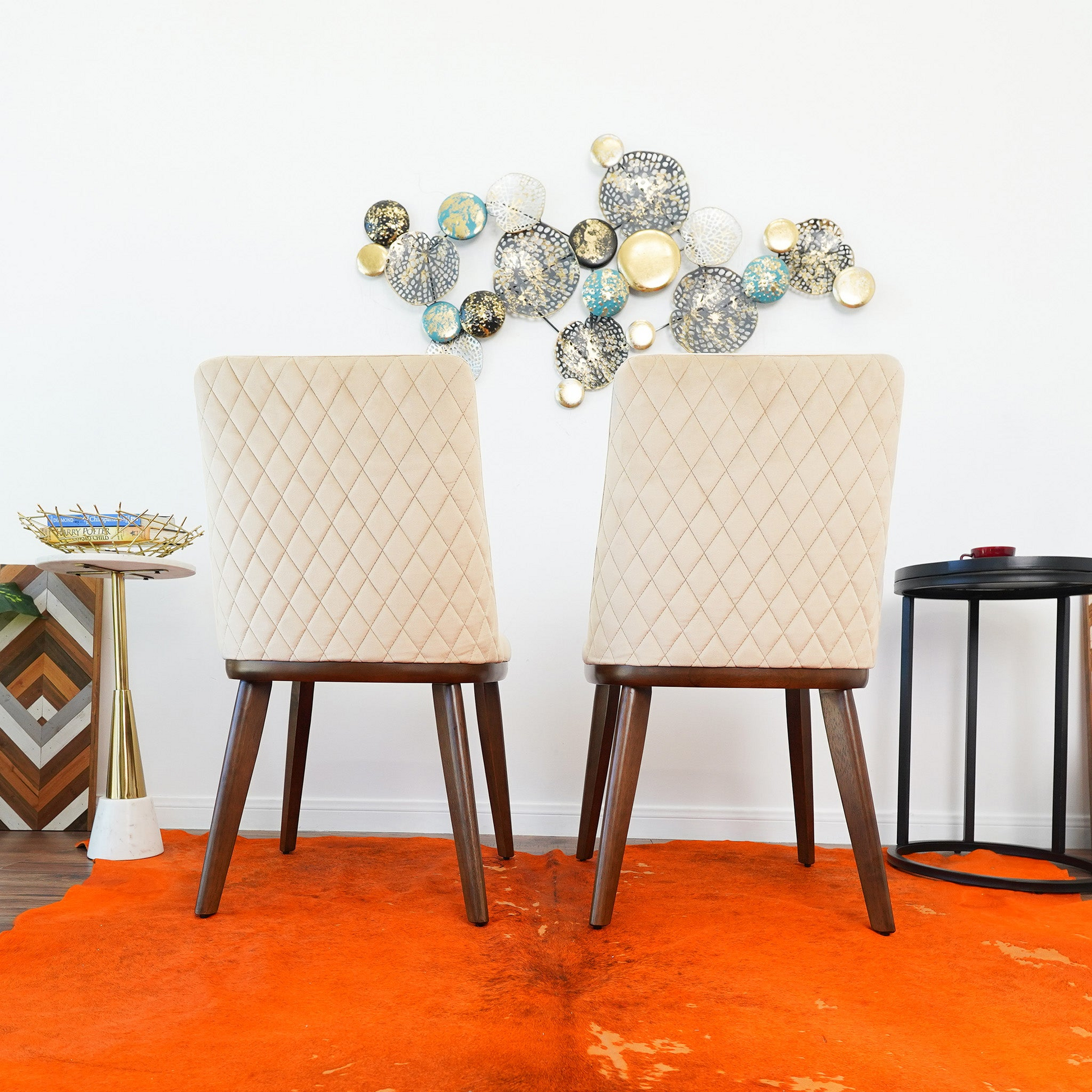 Pair of cream upholstered dining chairs with diamond tufting and dark wood legs