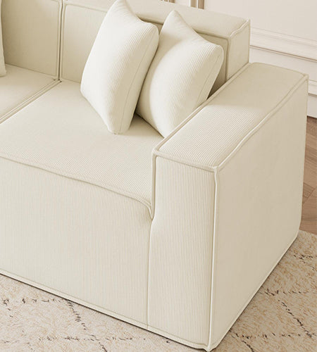 Cream corduroy sectional sofa with plush throw pillows a modern living room centerpiece