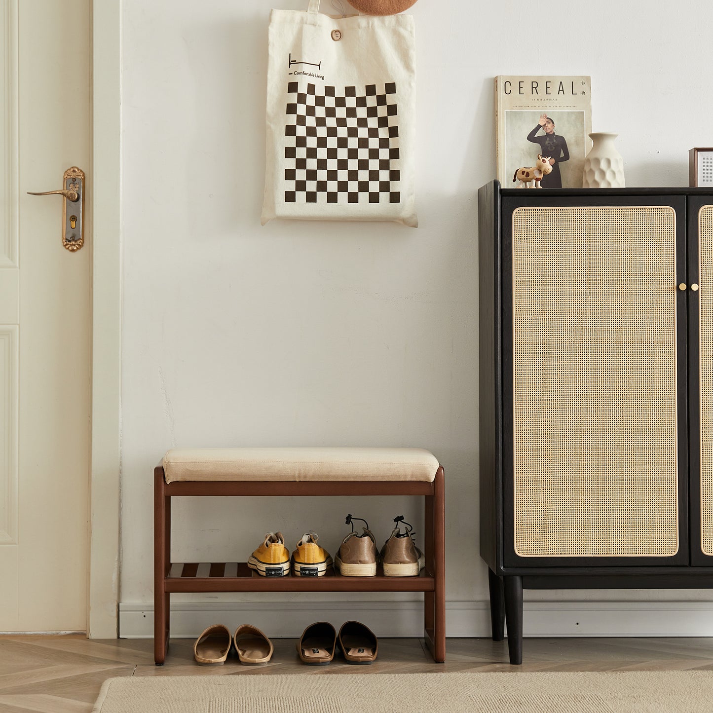 Wooden shoe bench with beige upholstered cushion holding yellow and grey sneakers on the second shelf