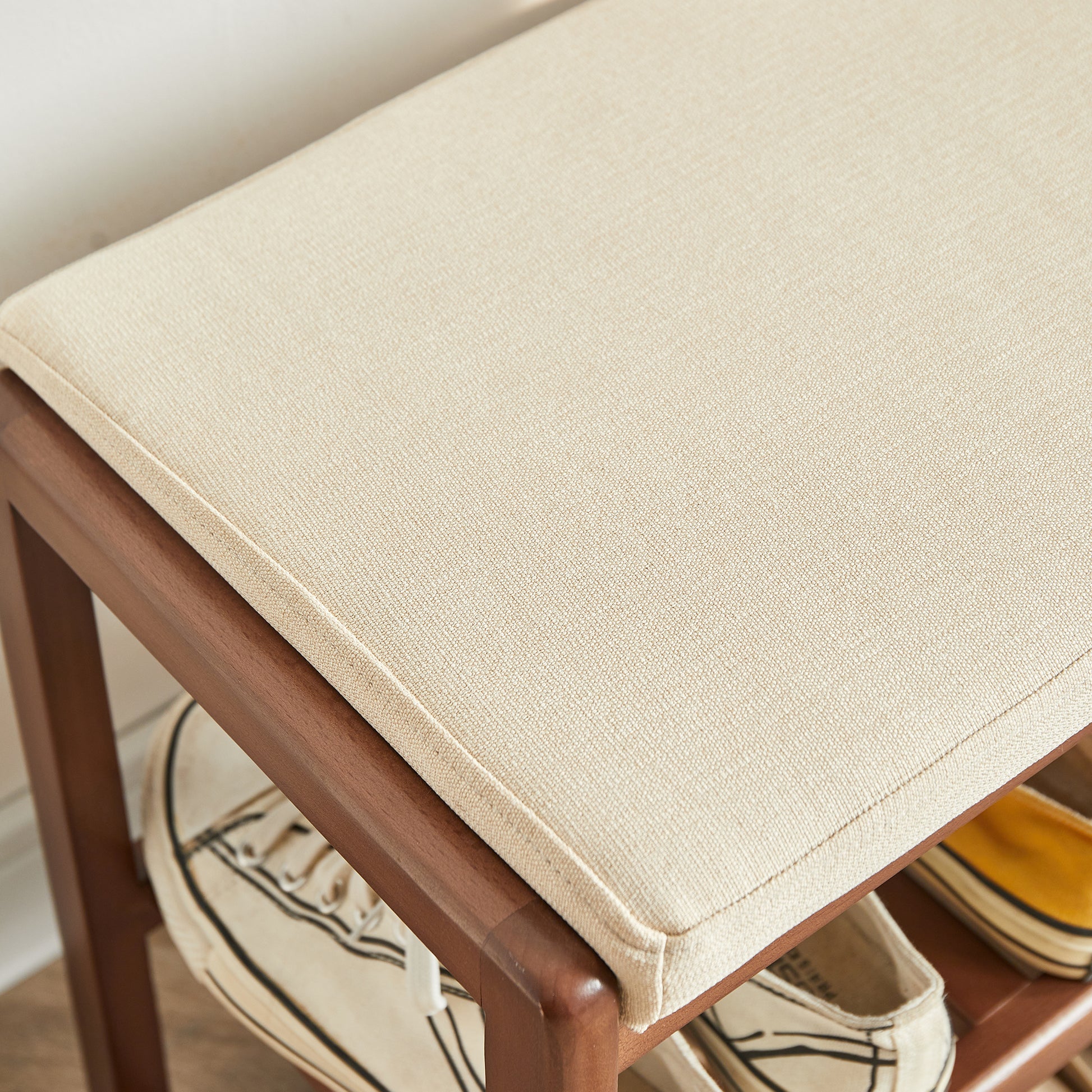 Natural linen upholstered bench with wooden frame and two shoe storage shelves