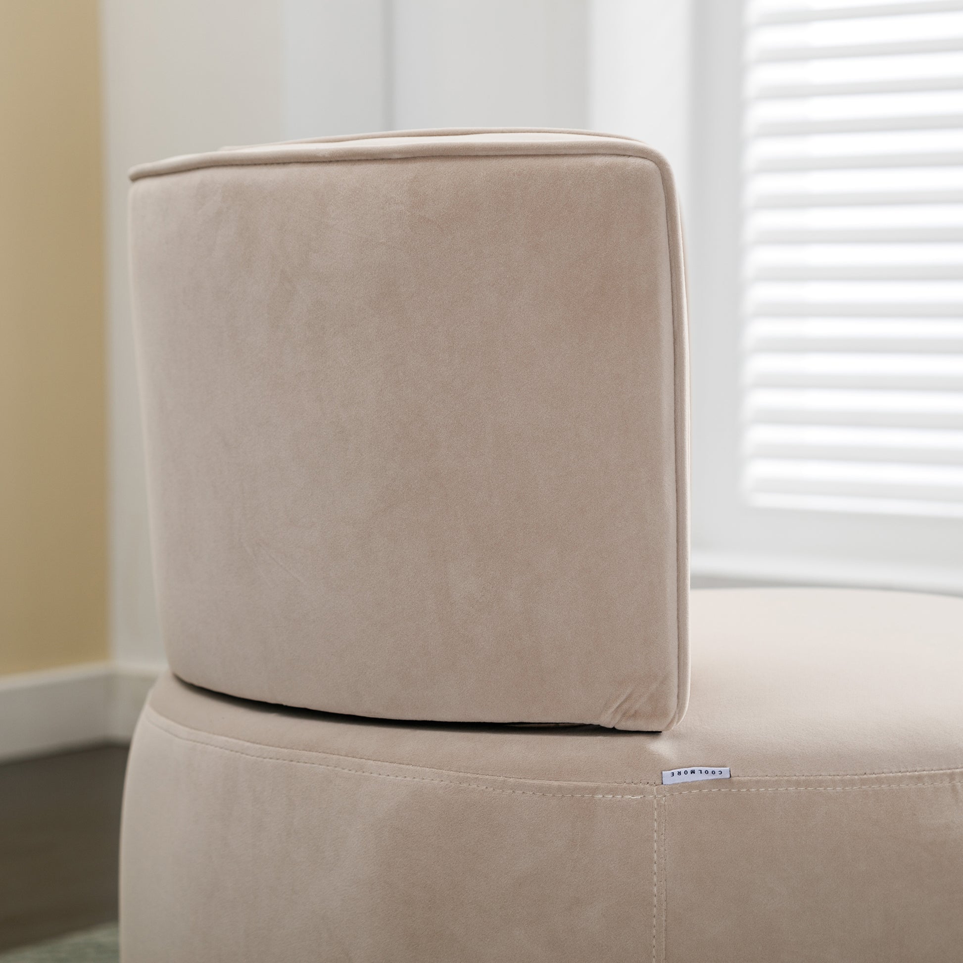 Closeup of a plush beige velvet armchair back and seat cushion showcasing soft texture