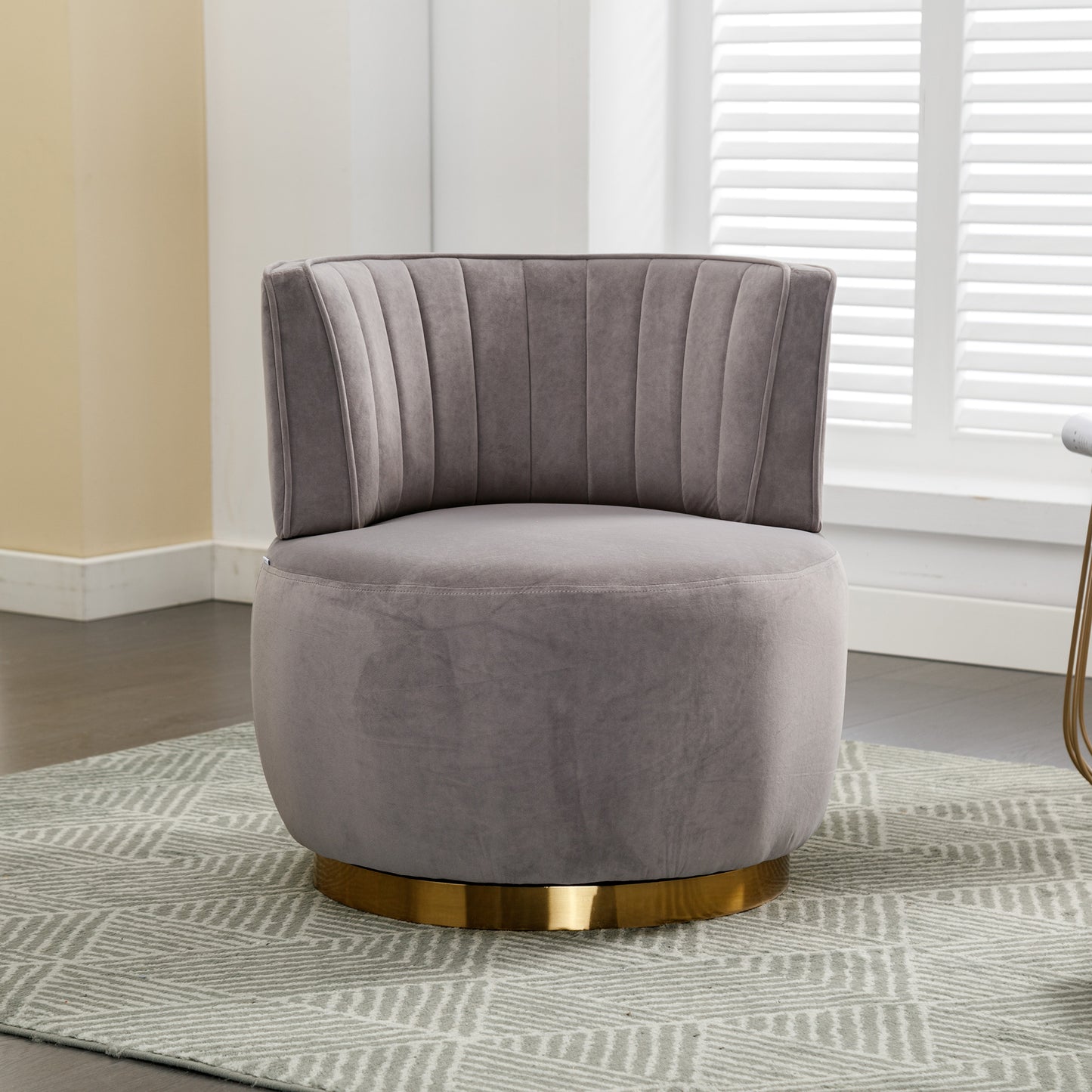 Plush grey velvet accent chair with channel tufting and a gold swivel base