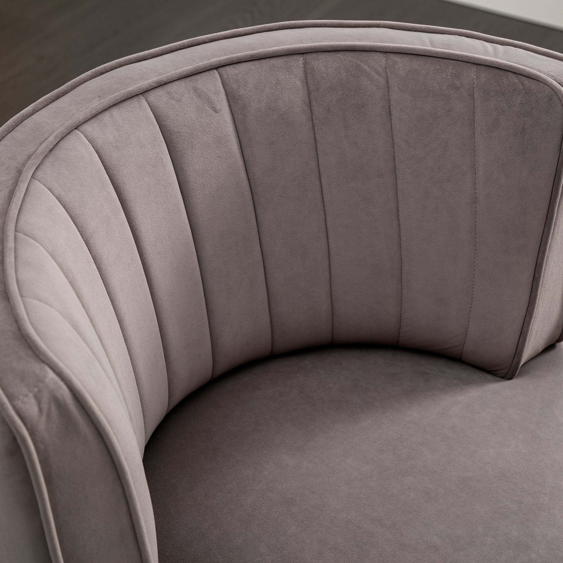 Closeup of plush gray velvet accent chair with channel tufting detail