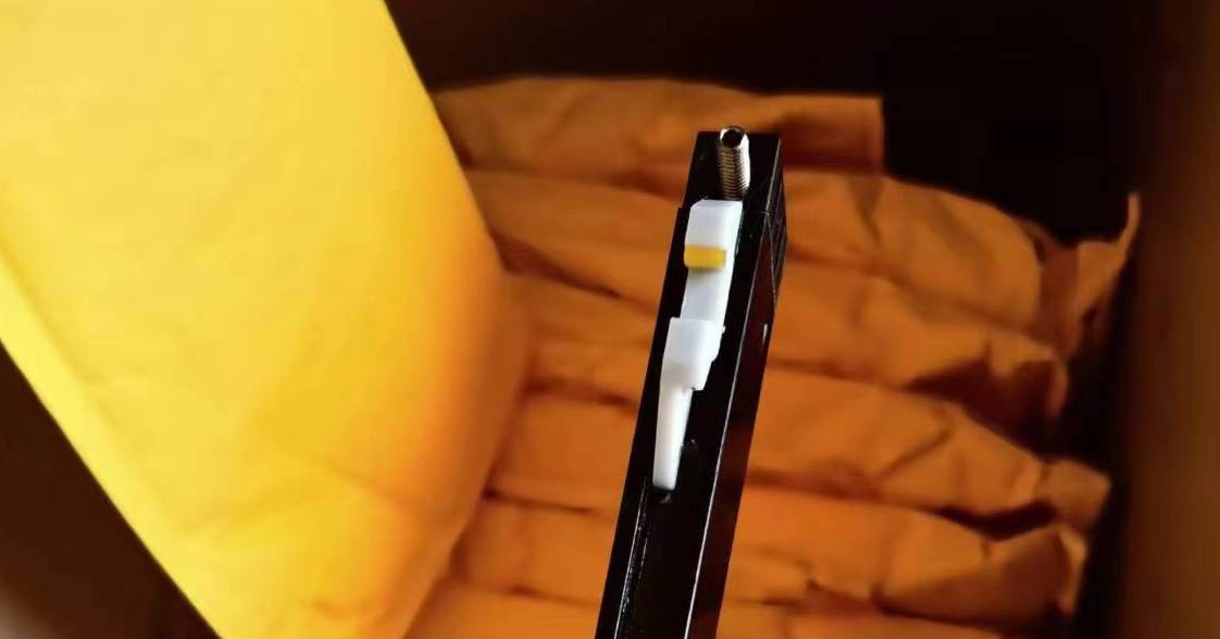 Black plastic cartridge with white and yellow components for a vape pen