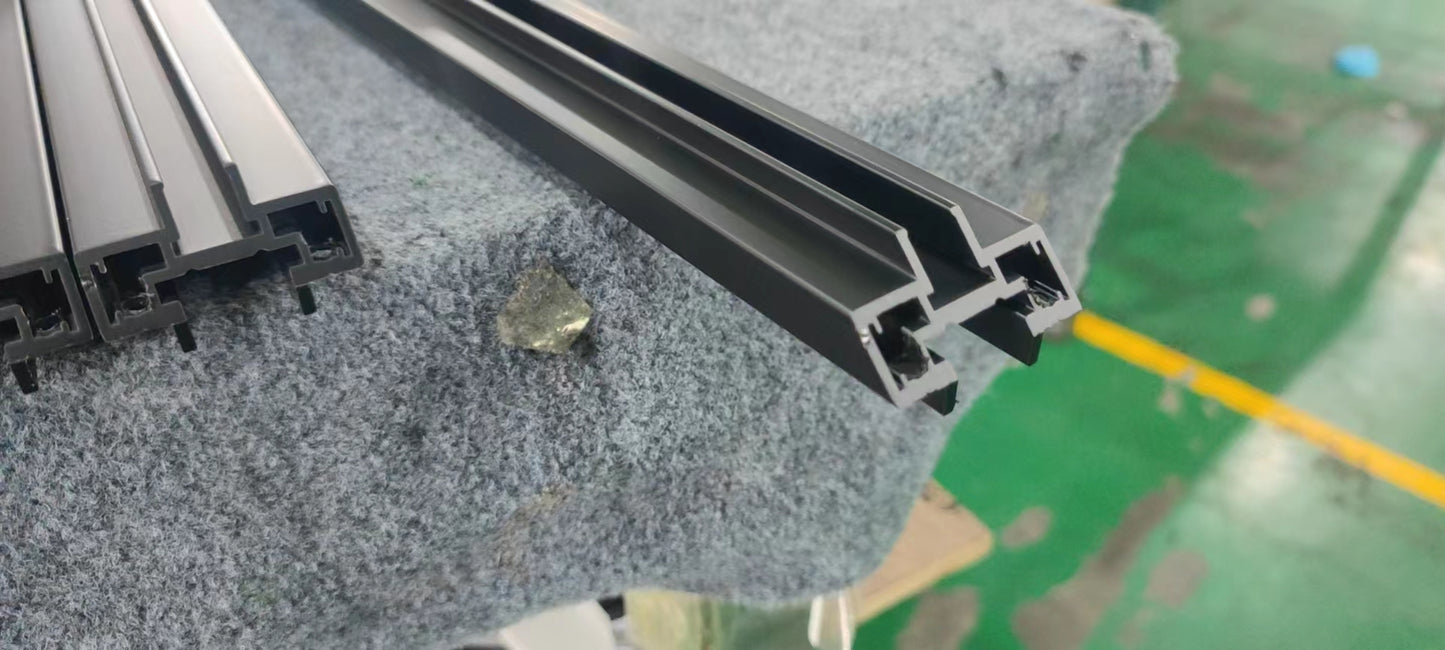 Black aluminum extrusion profile for window frames showing intricate interlocking channels