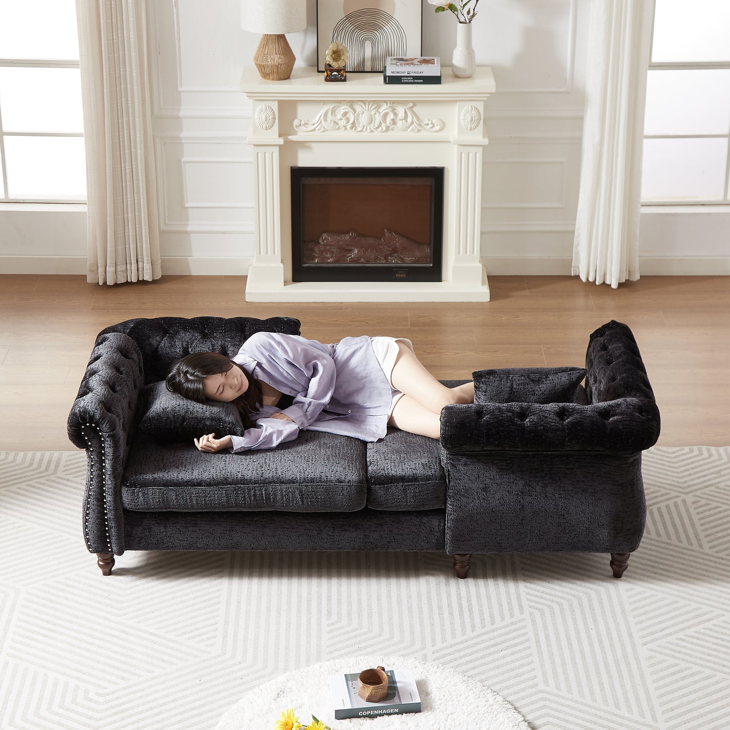 Dark gray tufted chesterfield sofa with silver nailhead trim and plush velvet upholstery