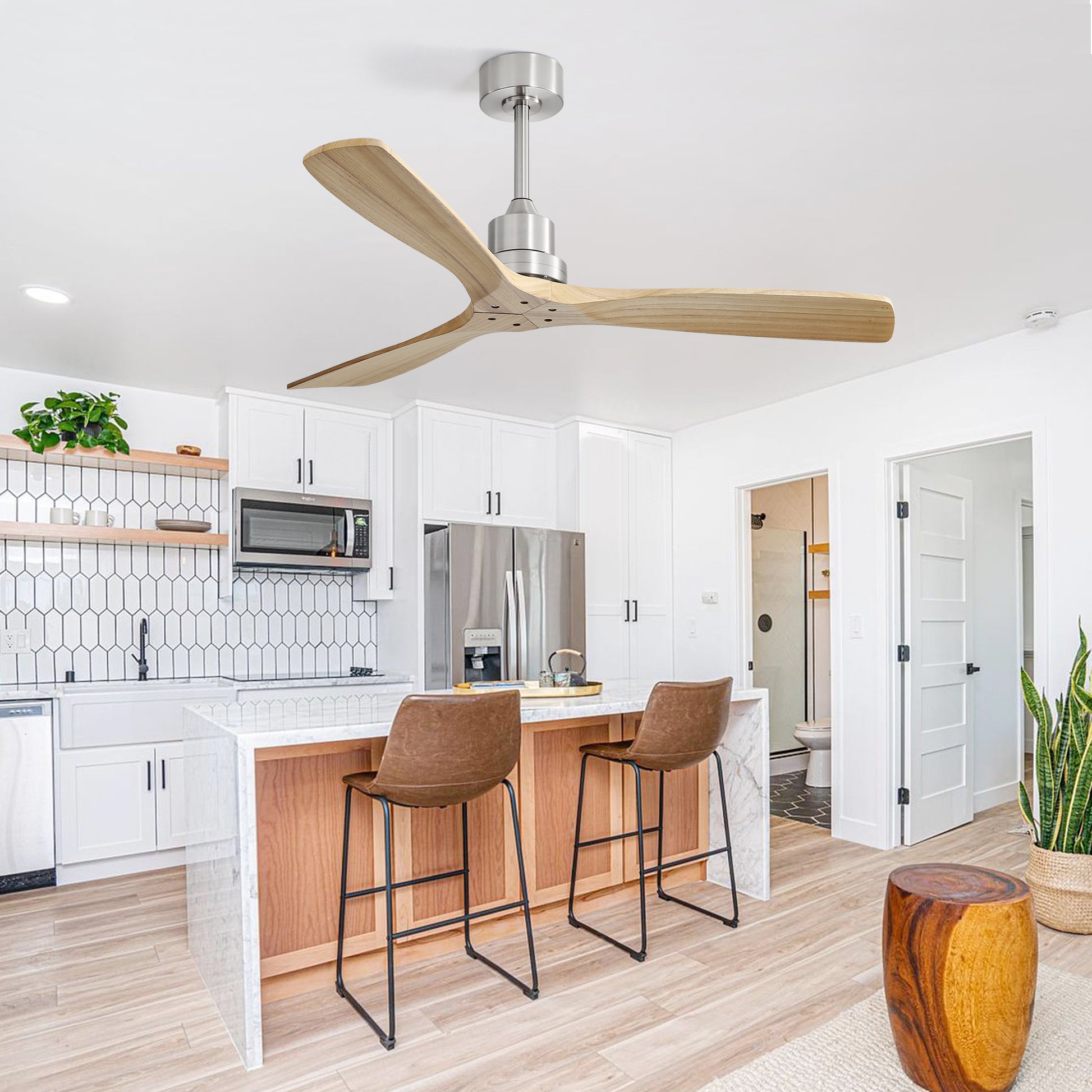Modern brushed nickel ceiling fan with three natural wood blades over kitchen island