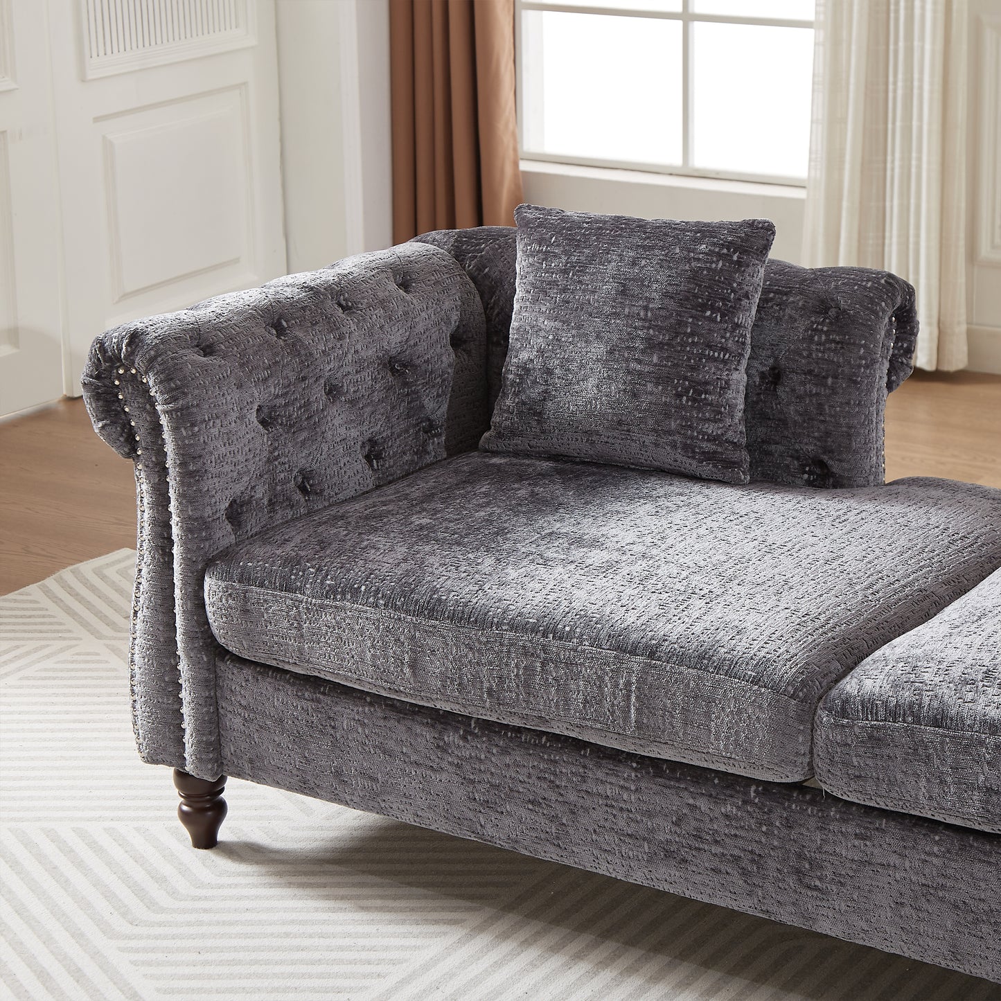 Tufted charcoal grey velvet chaise lounge with ornate details and plush seating