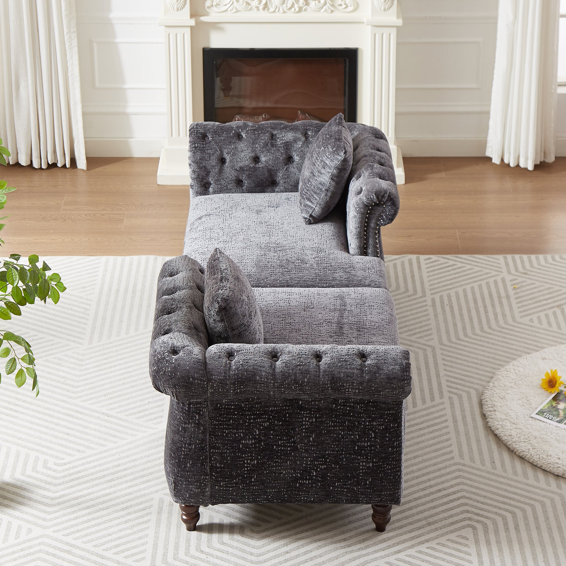 Tufted charcoal grey velvet chaise lounge with studded arms and lumbar pillow