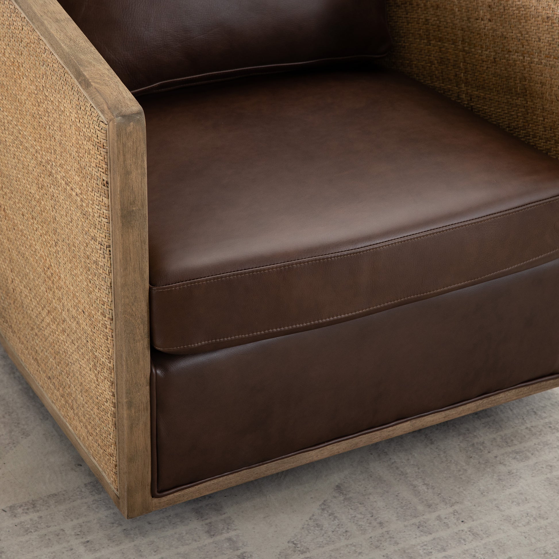 Brown leather armchair with woven cane side panels and wooden frame