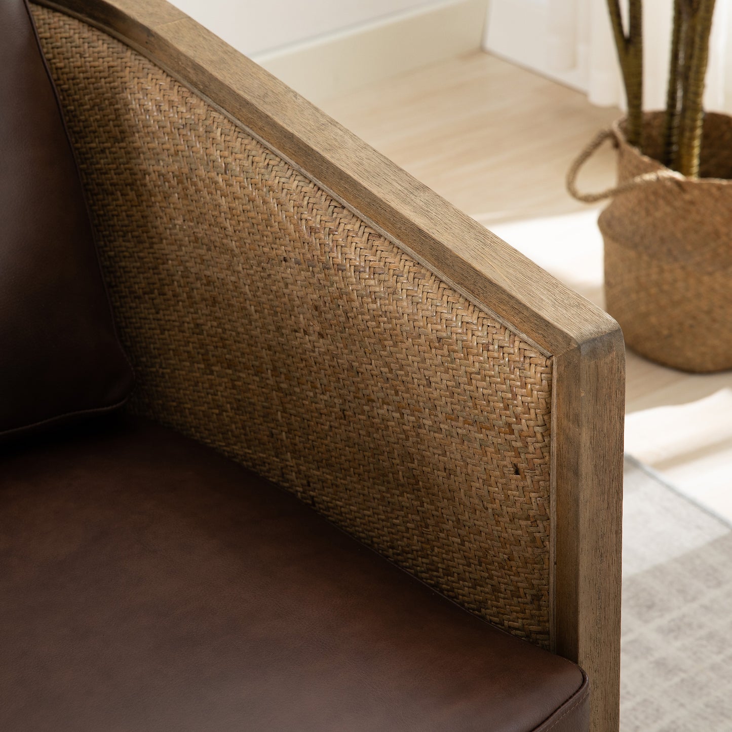 Closeup of a stylish brown leather armchair with natural woven cane side panel detail